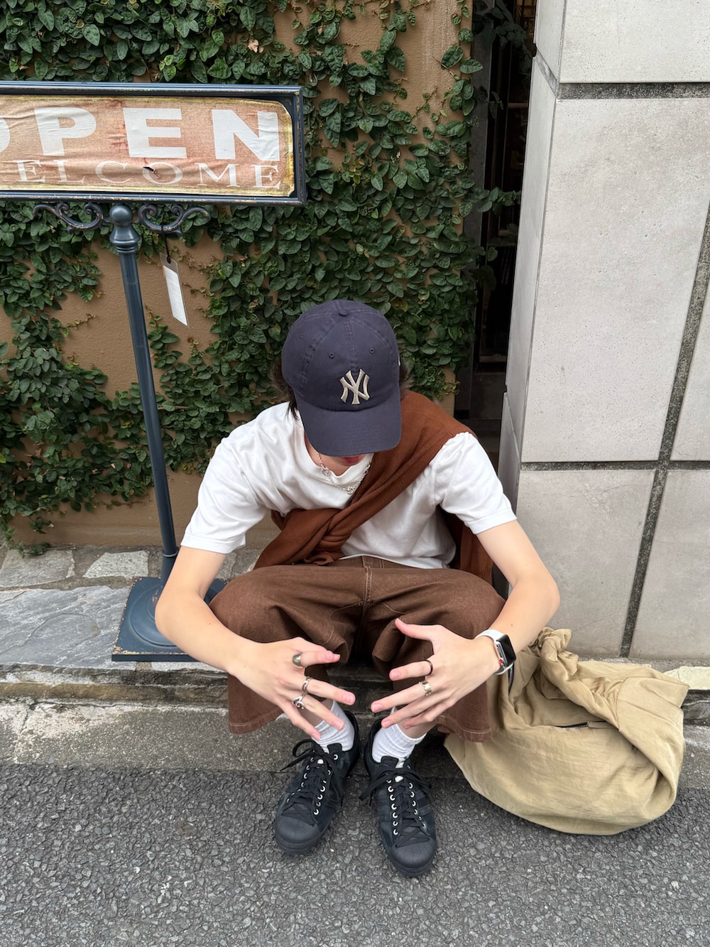 ブラウン系のカーディガン/ボレロ、ホワイト系のTシャツ/カットソー、ブラウン系のデニムパンツを着用したメンズの夏コーディネートの3枚目の写真