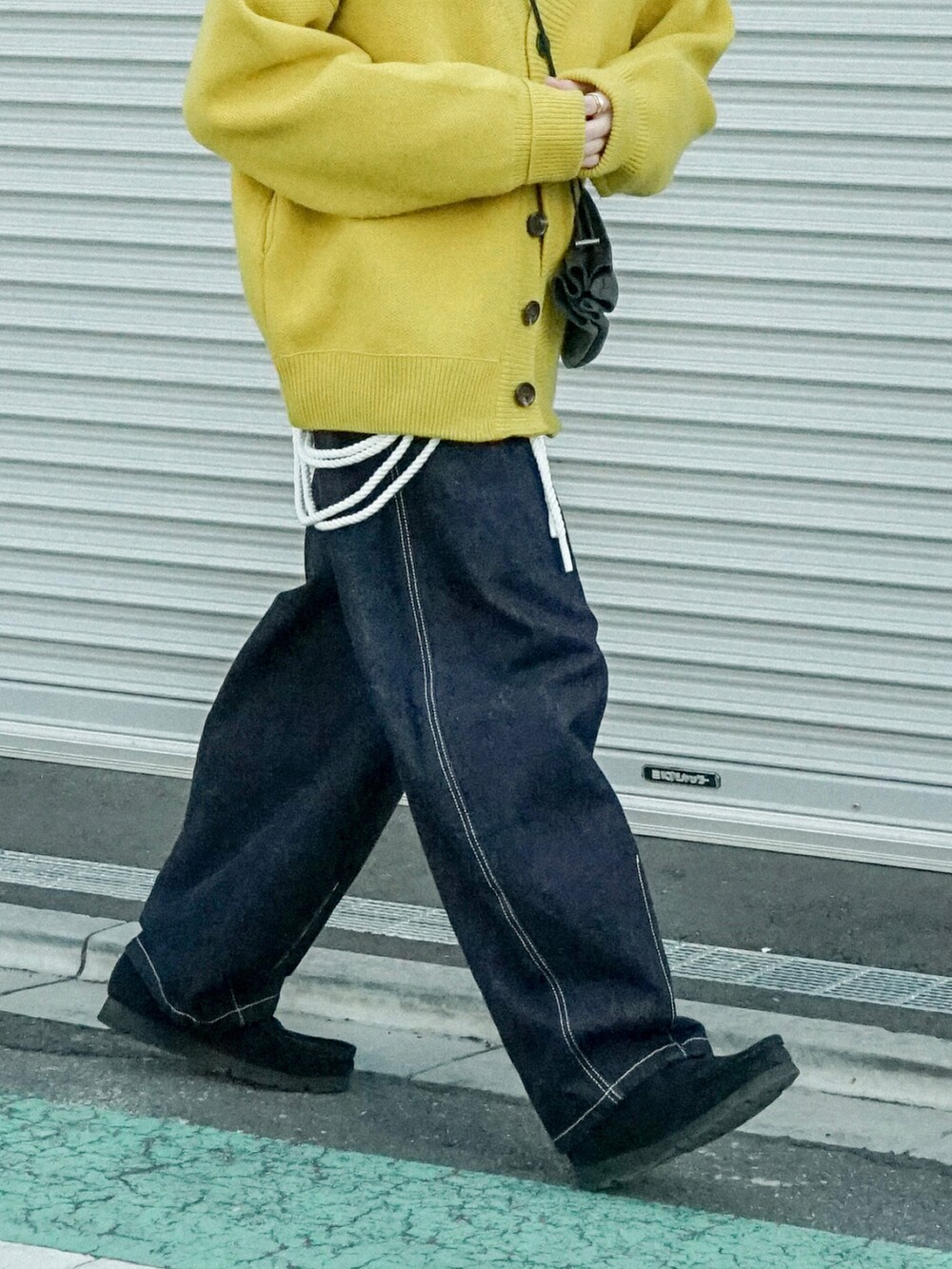 イエロー系のカーディガン/ボレロ、ブラック系のシャツ/ブラウス、ブルー系のデニムパンツを着用したメンズの冬コーディネートの4枚目の写真