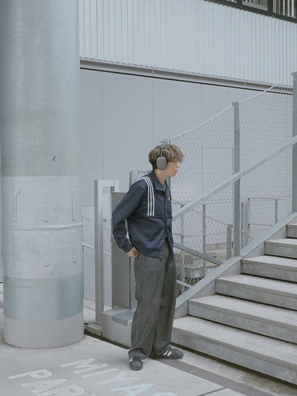 ブルー系のジャージ、グレー系のデニムパンツ、ブラック系のスニーカーを着用したメンズの春コーディネートの3枚目の写真