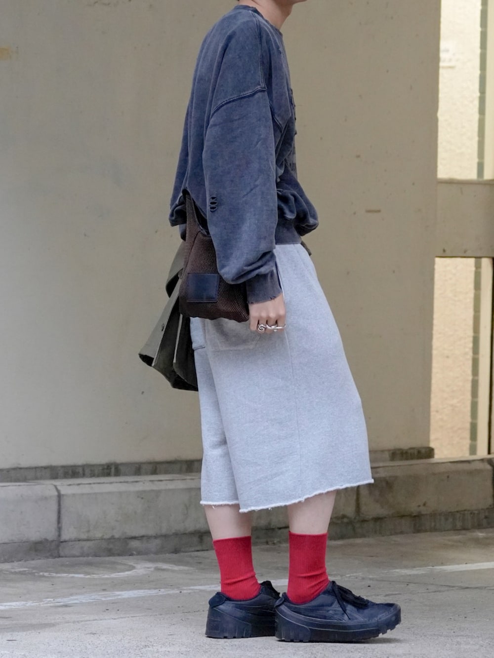 グレー系のスウェット、ブラック系のカバーオール、ブラウン系のショルダーバッグを着用したメンズの秋コーディネートの5枚目の写真