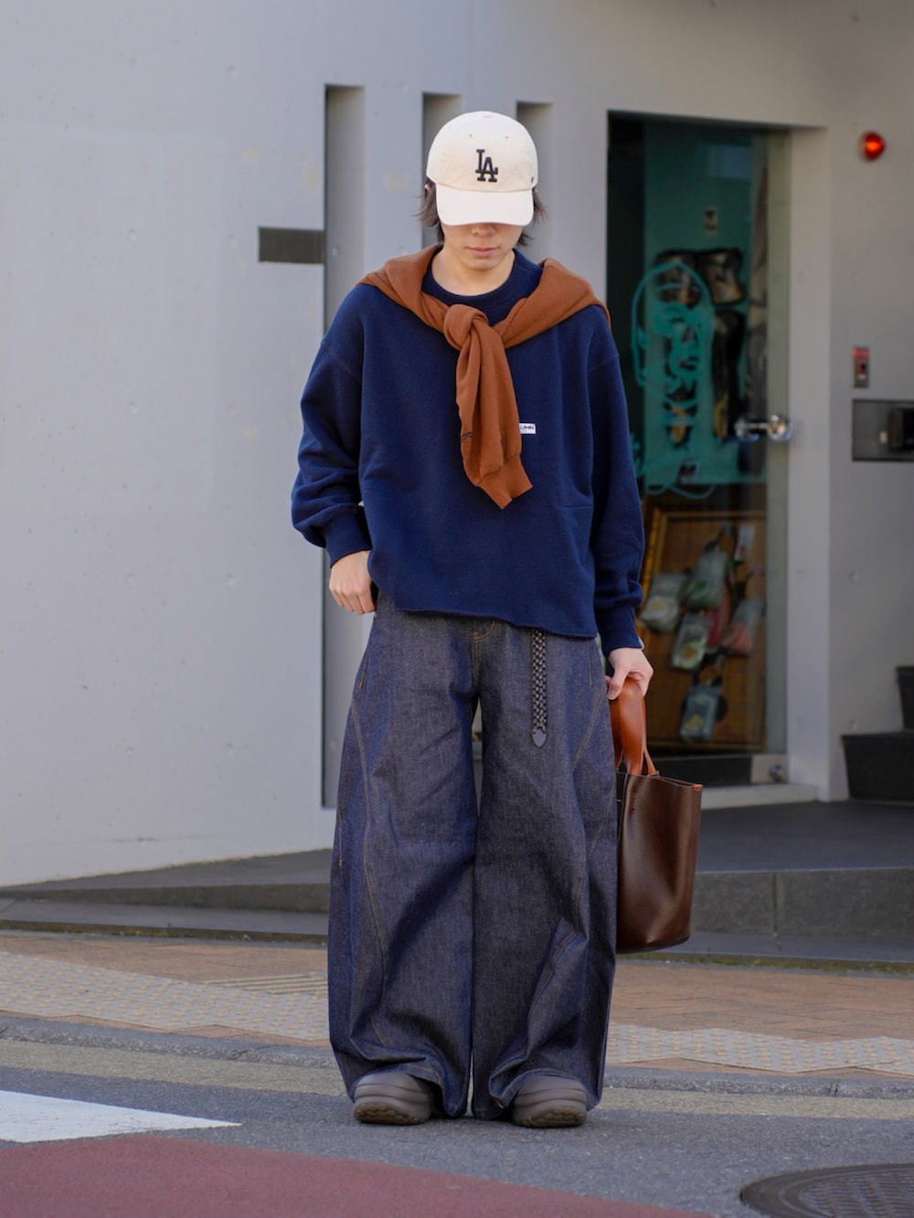 ブルー系のスウェット、ブラウン系のカーディガン/ボレロ、ブルー系のデニムパンツを着用したメンズの冬コーディネートの2枚目の写真