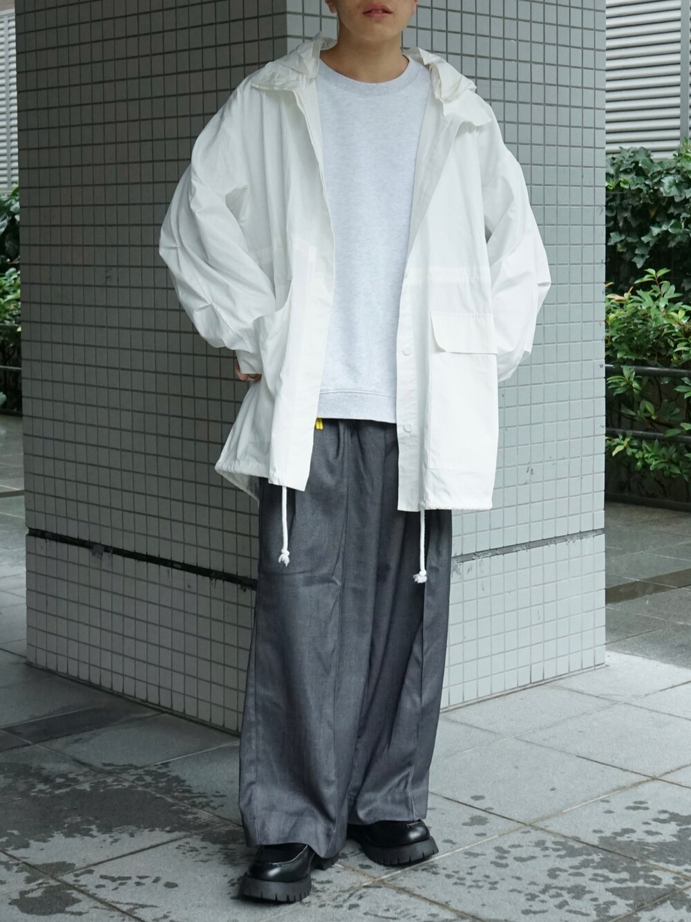 ホワイト系のマウンテンパーカー、グレー系のスウェット、グレー系のスラックスを着用したメンズの秋コーディネートの5枚目の写真