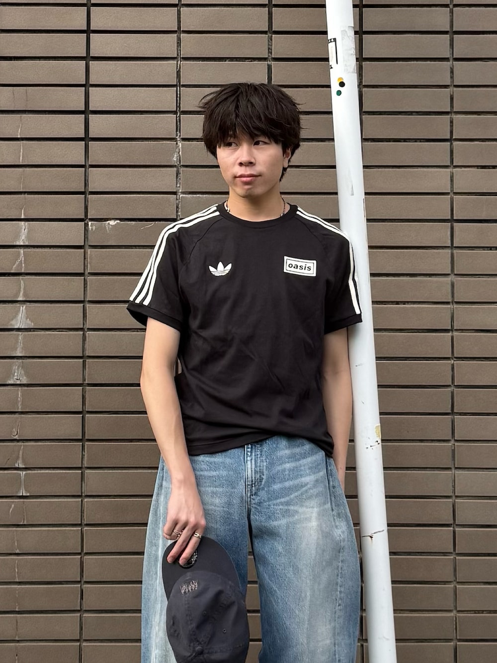 ブラック系のTシャツ/カットソー、ブルー系のデニムパンツ、ブラウン系のスニーカーを着用したメンズの夏コーディネートの3枚目の写真