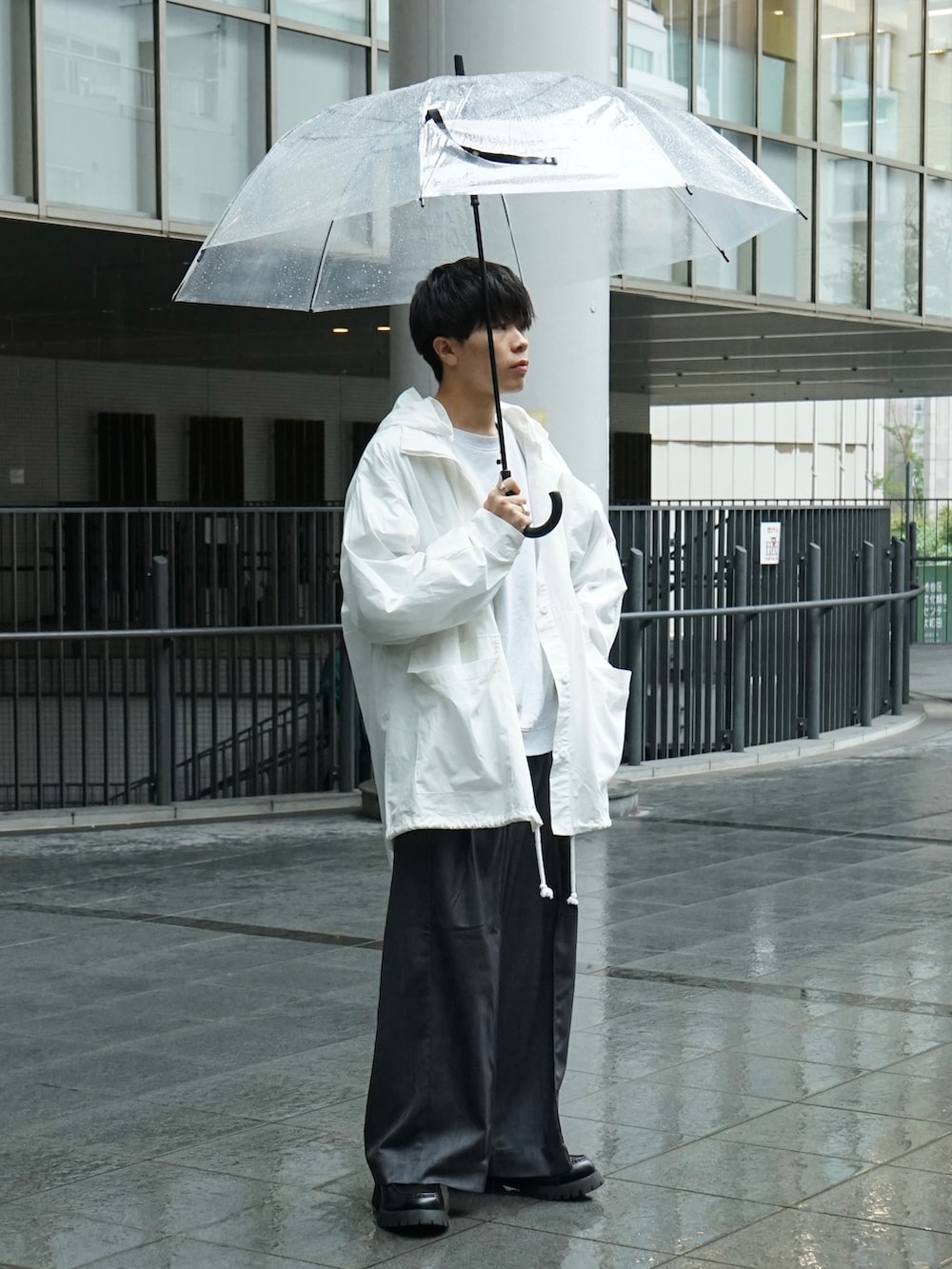 ホワイト系のマウンテンパーカー、グレー系のスウェット、グレー系のスラックスを着用したメンズの秋コーディネートの2枚目の写真