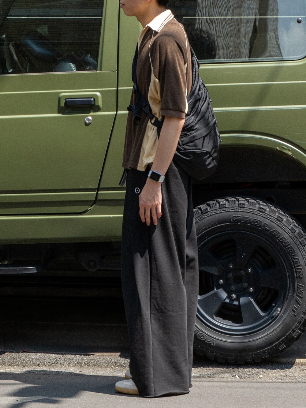 ブラウン系のポロシャツ、ブラック系のスウェットパンツ、ブラック系のショルダーバッグを着用したメンズの夏コーディネートの5枚目の写真