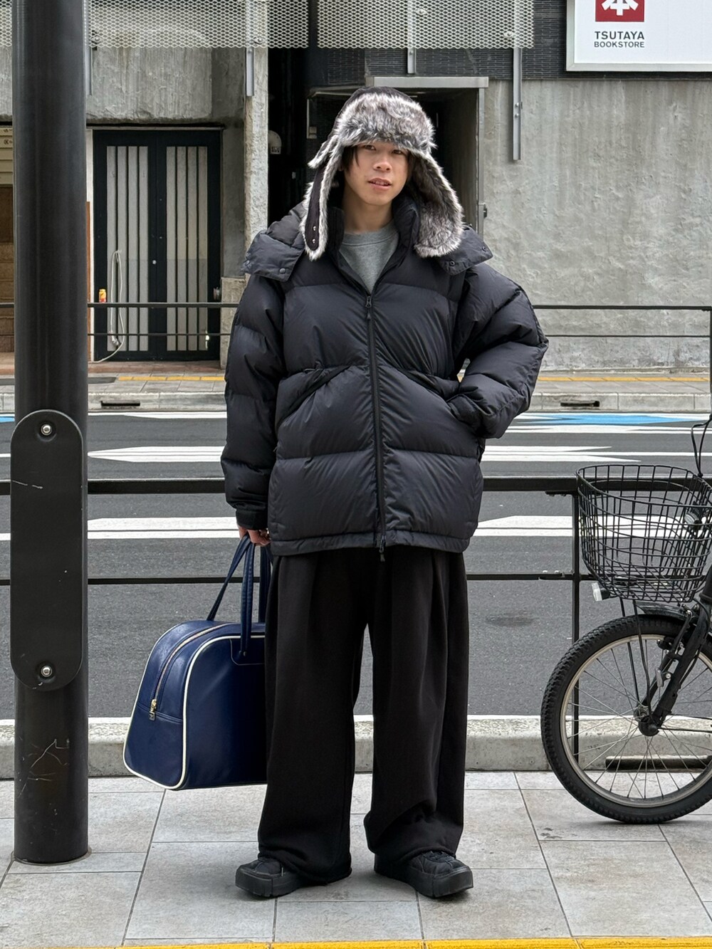 ブラック系のダウンジャケット/コート、グレー系のスウェット、ブラック系のスウェットパンツを着用したメンズの冬コーディネートの2枚目の写真