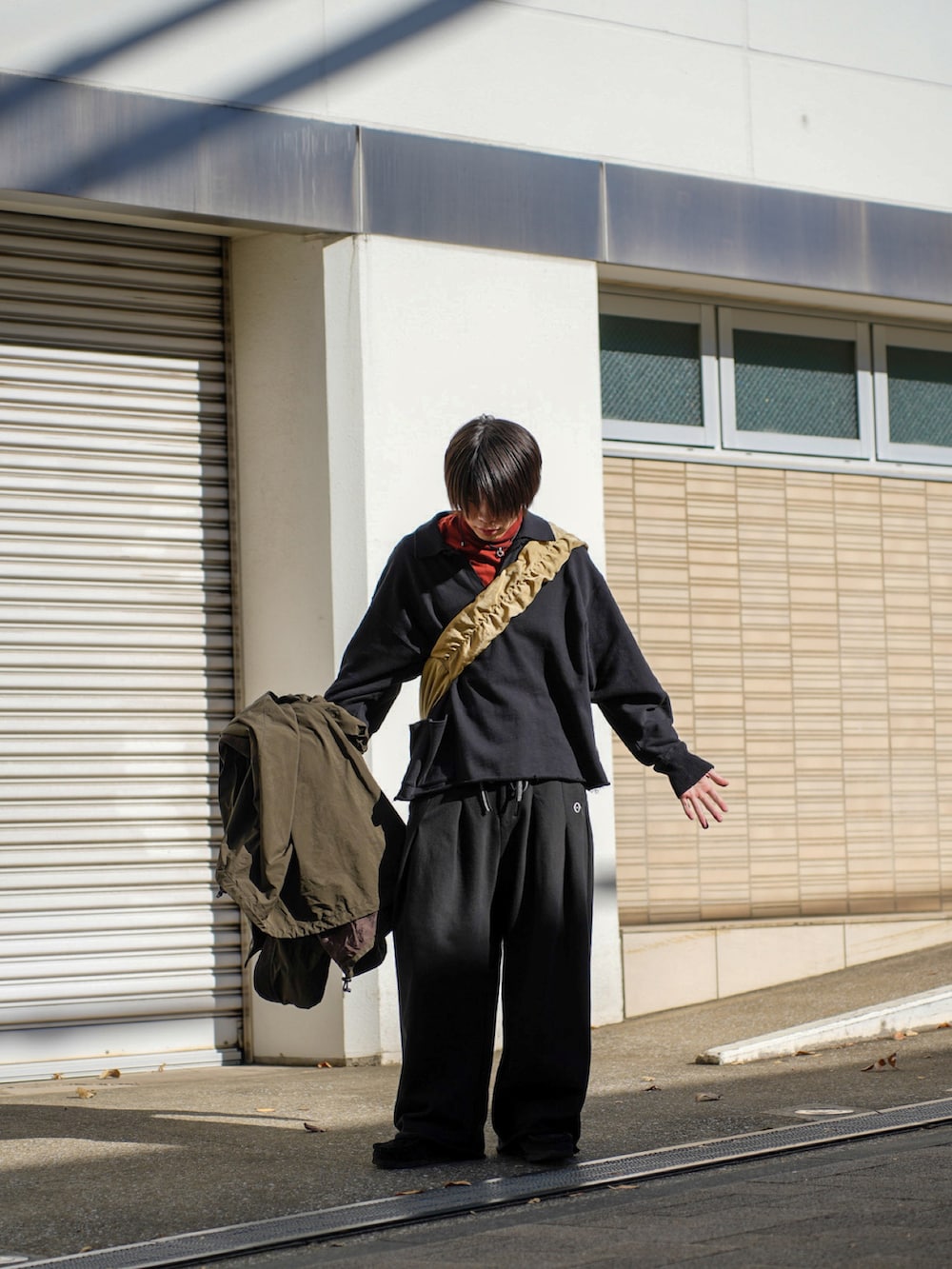 ブラック系のスウェット、ブラック系のスウェットパンツ、ベージュ系のショルダーバッグを着用したメンズの冬コーディネートの4枚目の写真