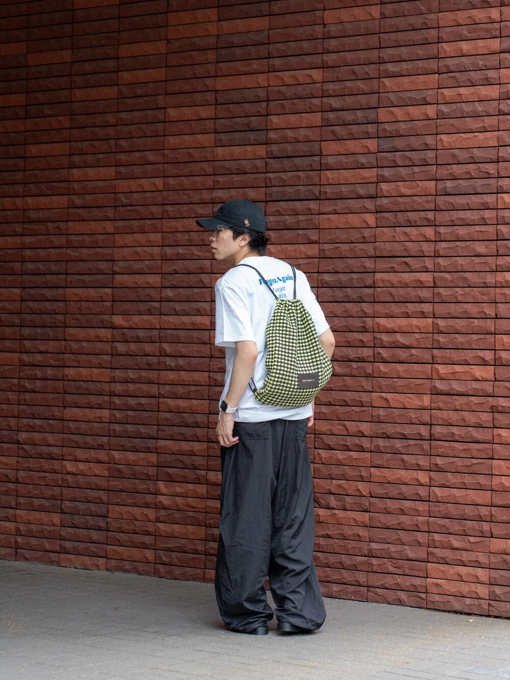 その他のTシャツ/カットソー、ブラック系のその他パンツ、イエロー系のエコバッグ/サブバッグを着用したメンズの夏コーディネートの3枚目の写真