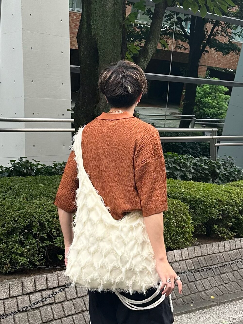 ブラウン系のポロシャツ、ブラック系のカーゴパンツ、ホワイト系のショルダーバッグを着用したメンズの夏コーディネートの4枚目の写真