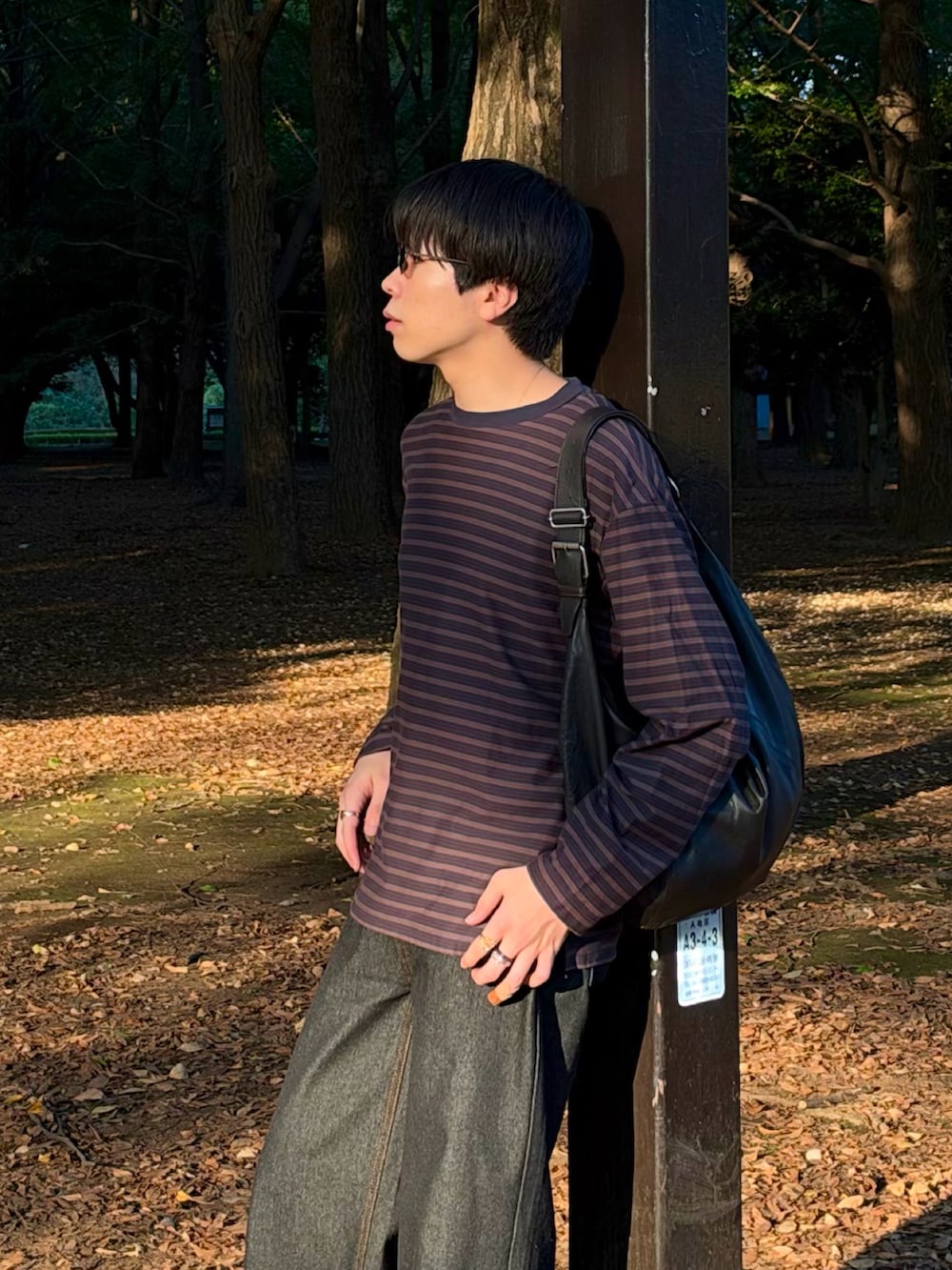 グレー系のTシャツ/カットソー、ブラック系のデニムパンツ、ブラック系のブーツを着用したメンズの秋コーディネートの3枚目の写真