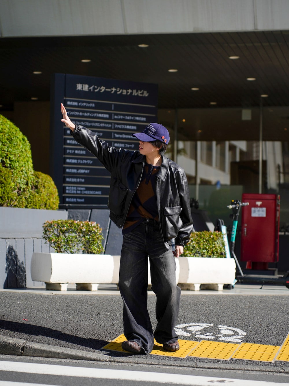 ブラック系のブルゾン、ブラック系のデニムパンツ、ブラウン系のスニーカーを着用したメンズの秋コーディネートの4枚目の写真