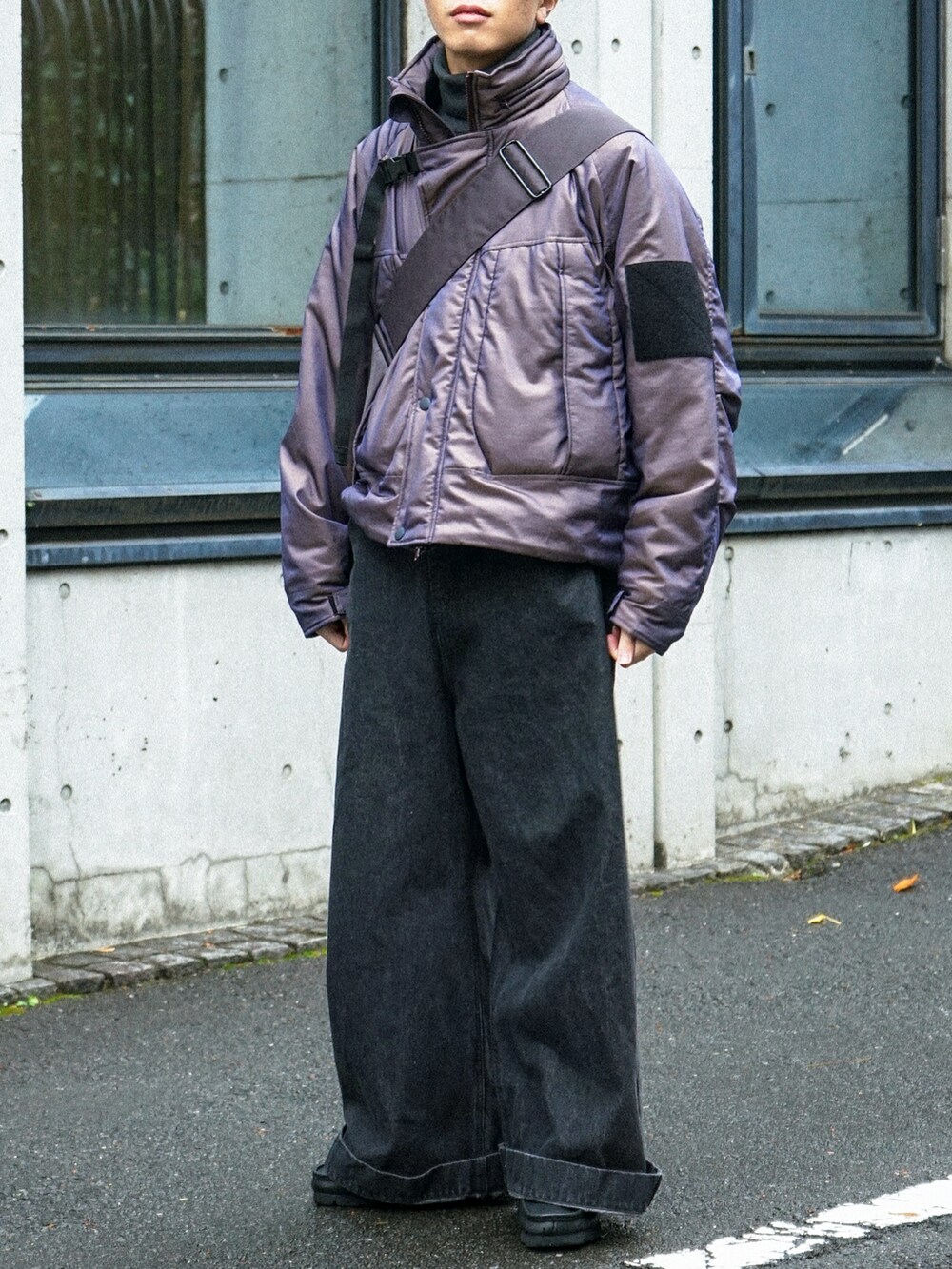 パープル系のブルゾン、ブラック系のデニムパンツ、グレー系のショルダーバッグを着用したメンズの冬コーディネートの5枚目の写真