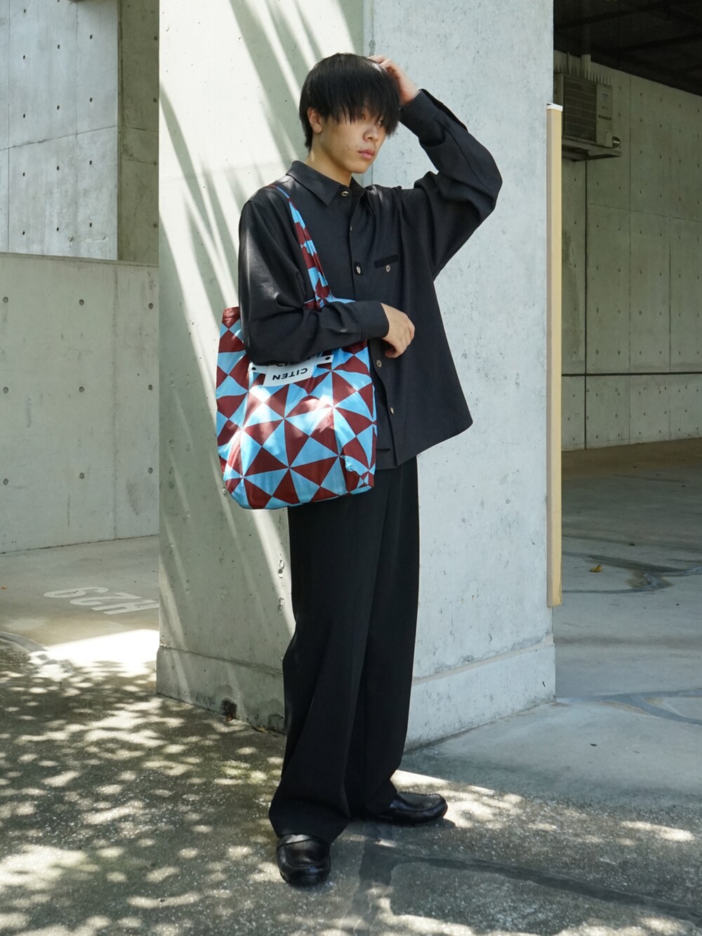 グレー系のシャツ/ブラウス、ブラック系のスラックス、ブルー系のトートバッグを着用したメンズの夏コーディネートの4枚目の写真