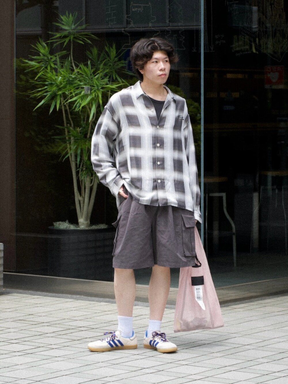 グレー系のシャツ/ブラウス、グレー系のカーゴパンツ、ピンク系のトートバッグを着用したメンズの春コーディネートの3枚目の写真
