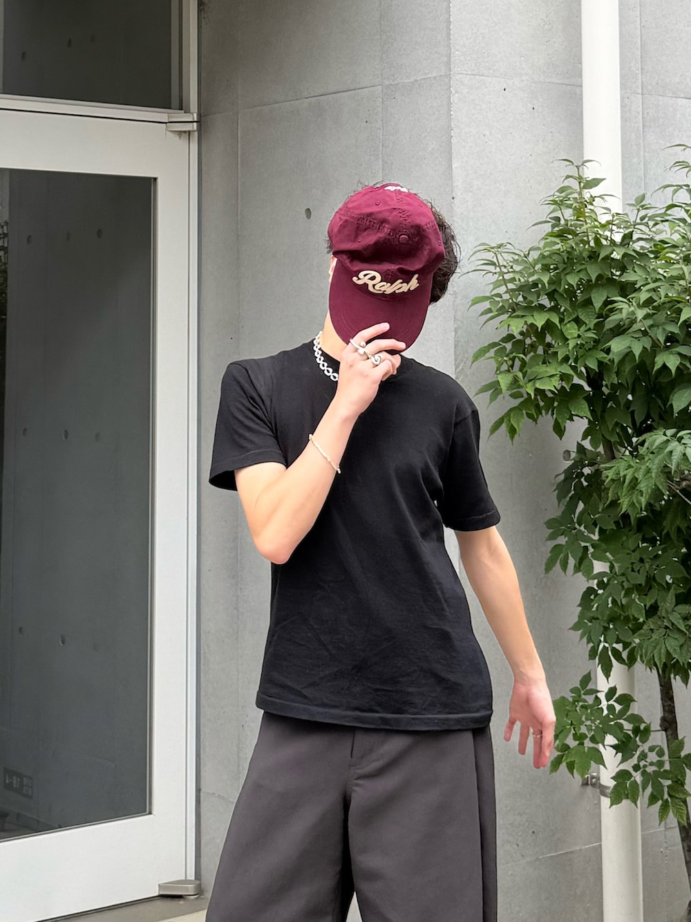 ブラック系のTシャツ/カットソー、グレー系のスラックス、ブラック系のサンダルを着用したメンズの夏コーディネートの2枚目の写真