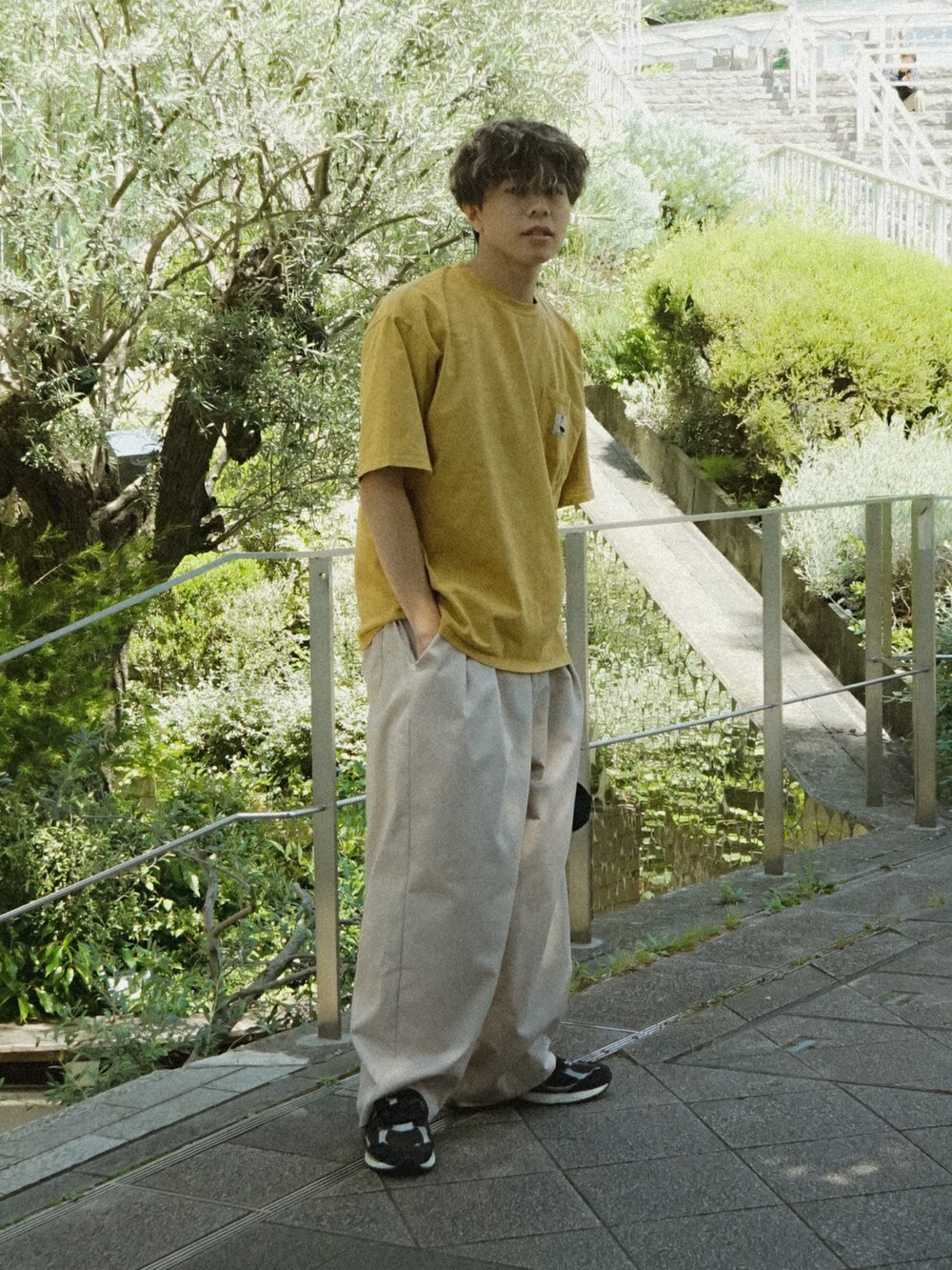 イエロー系のTシャツ/カットソー、ベージュ系のその他パンツ、ブラック系のショルダーバッグを着用したメンズの春コーディネートの2枚目の写真
