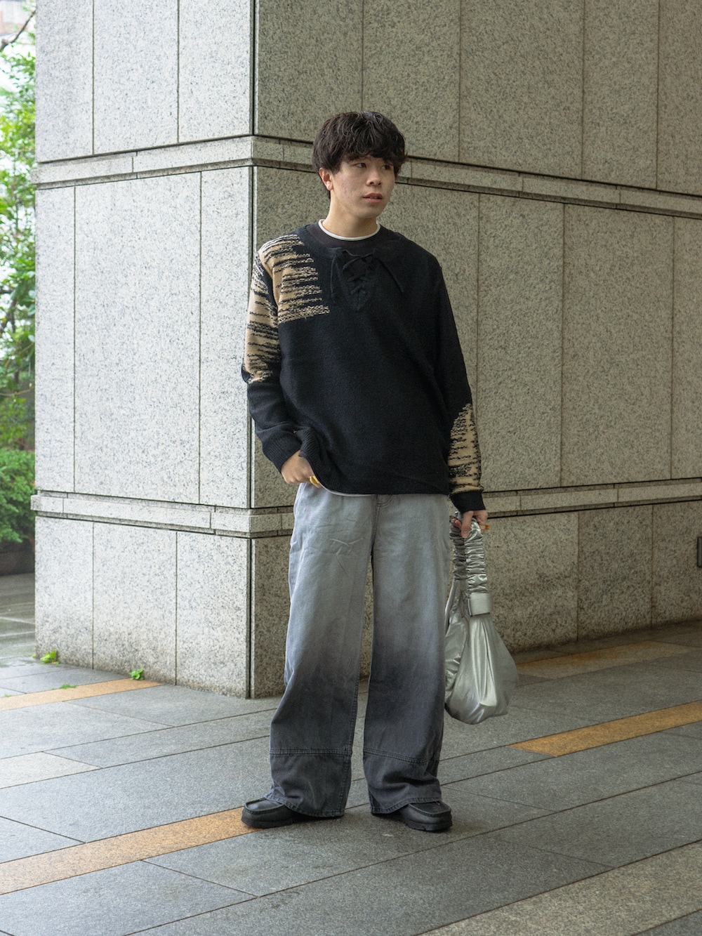 ブラック系のニット/セーター、ブラック系のデニムパンツ、ブラック系のブーツを着用したメンズの春コーディネートの2枚目の写真