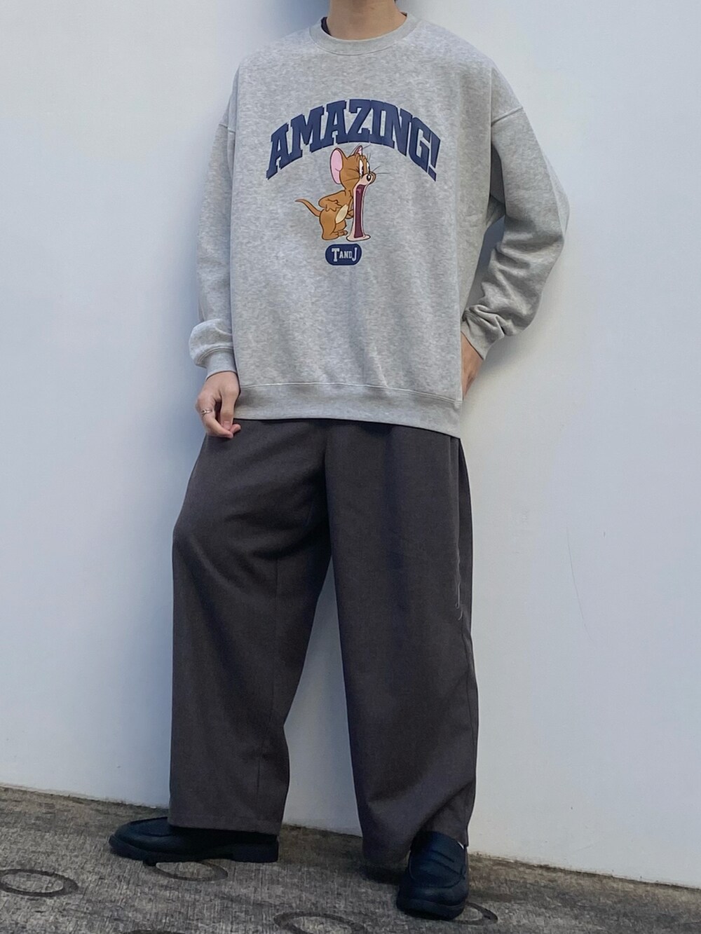 グレー系のスウェット、ベージュ系のスラックス、ブラック系のローファーを着用したメンズの冬コーディネートの3枚目の写真