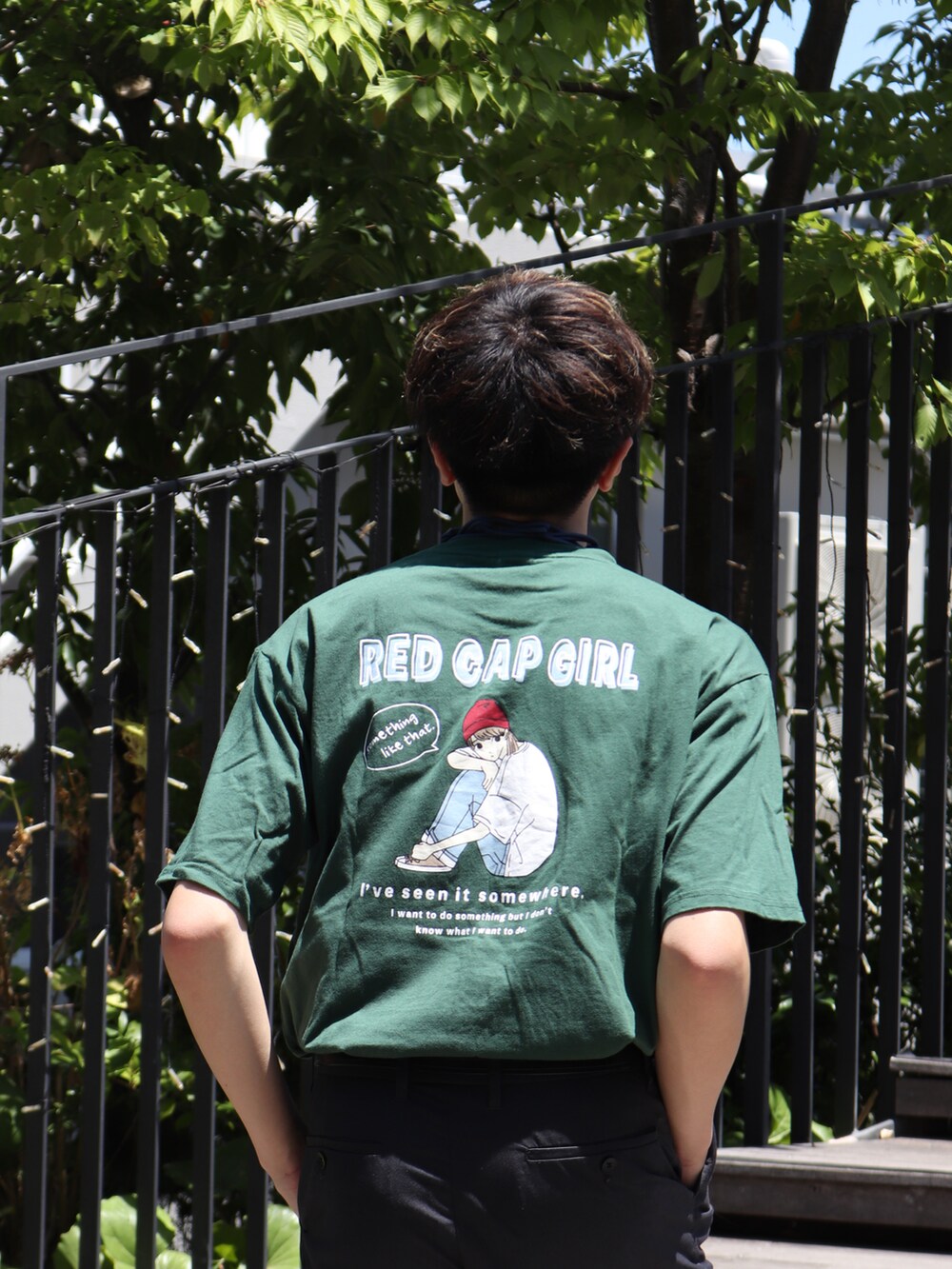 グリーン系のTシャツ/カットソー、グレー系のスラックス、ブルー系のウォレットチェーンを着用したメンズの夏コーディネートの4枚目の写真