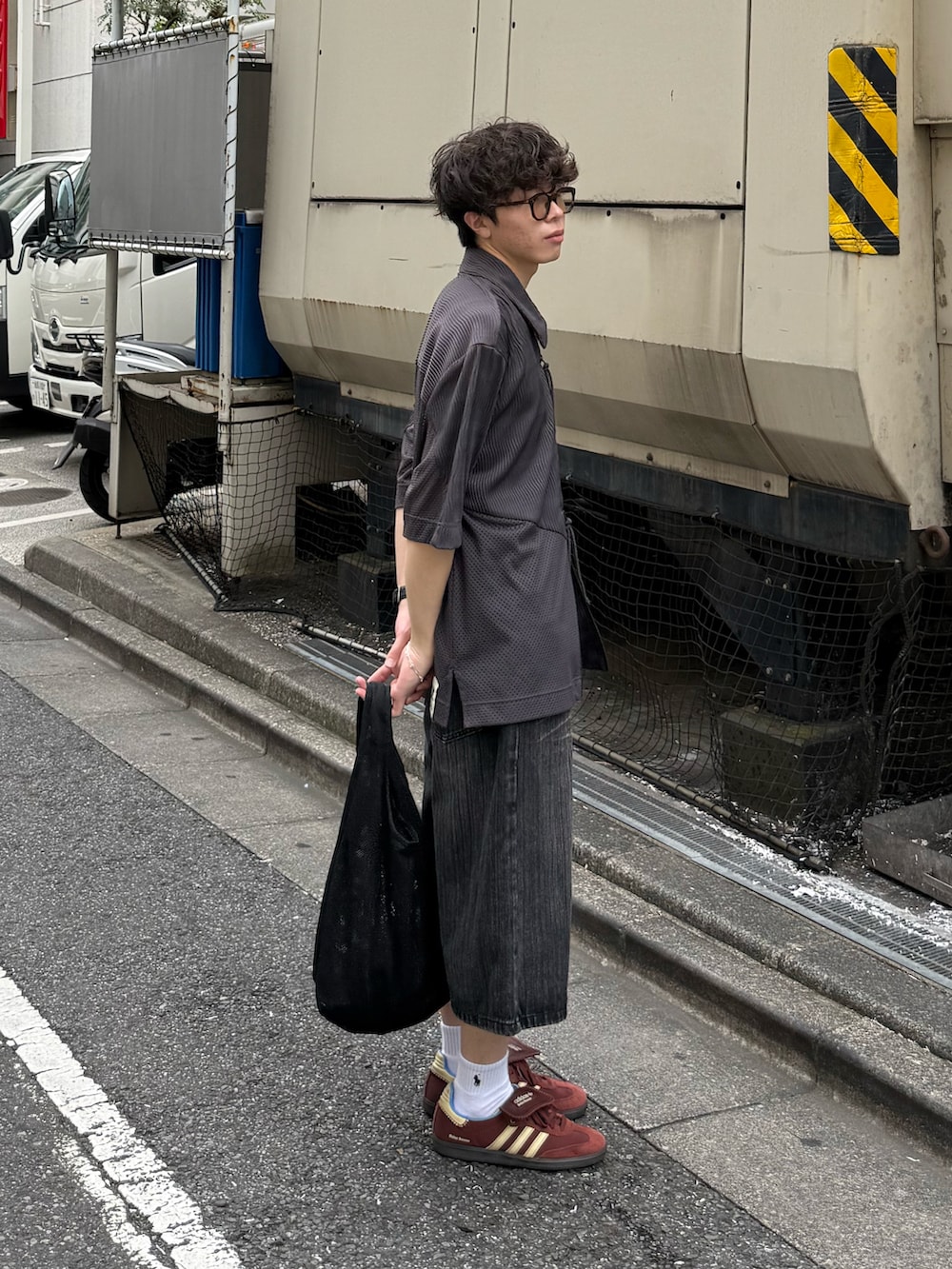 グレー系のデニムパンツ、ブラック系のショルダーバッグ、グレー系のトップスを着用したメンズの夏コーディネートの2枚目の写真
