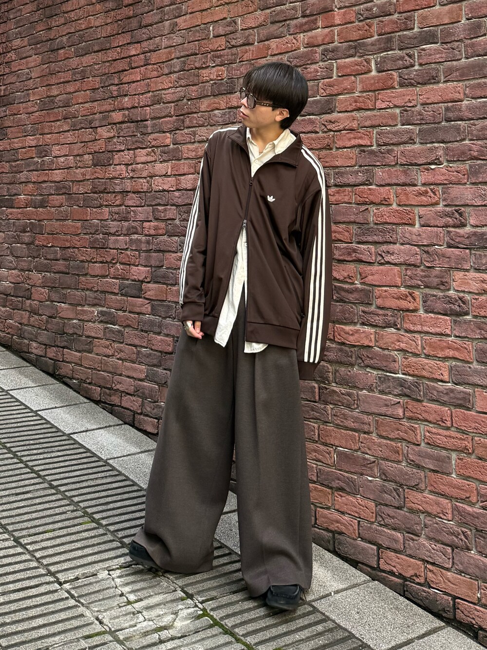 ブラウン系のジャージ、ブラウン系のスラックス、ブラック系のモカシン/デッキシューズを着用したメンズの秋コーディネートの2枚目の写真