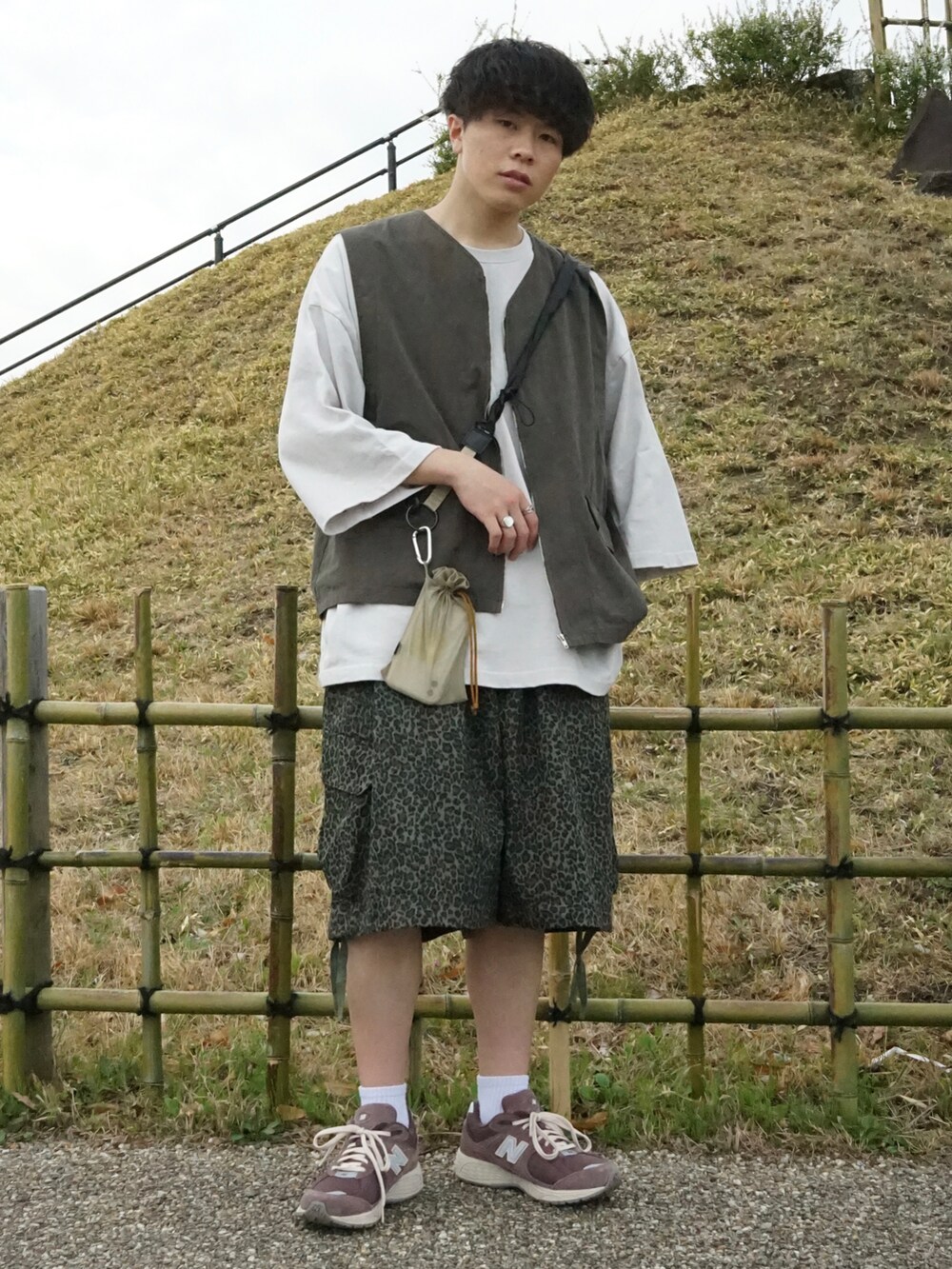 グレー系のベスト、グレー系のTシャツ/カットソー、グリーン系のその他パンツを着用したメンズの春コーディネートの3枚目の写真
