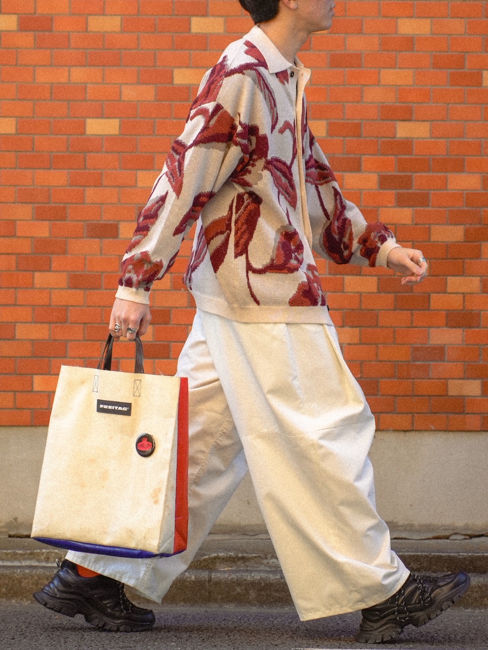 ホワイト系のカーディガン/ボレロ、ホワイト系のチノパンツ、ホワイト系のトートバッグを着用したメンズの春コーディネートの5枚目の写真