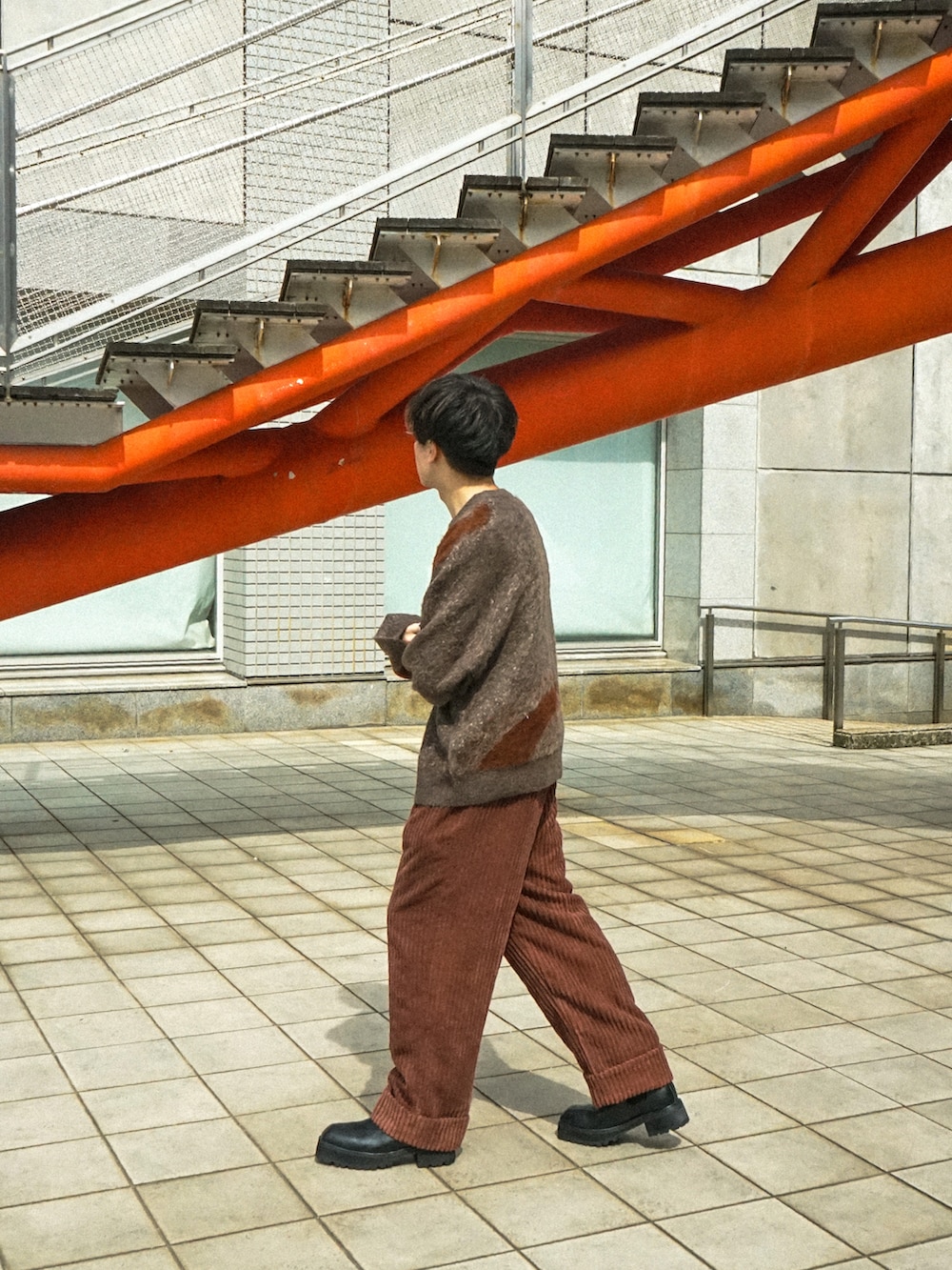 ブラウン系のニット/セーター、ブラウン系のその他パンツ、ブラック系のブーツを着用したメンズの秋コーディネートの3枚目の写真