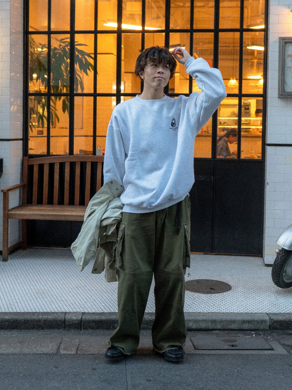 グレー系のスウェット、グリーン系のカーゴパンツ、ベージュ系のマウンテンパーカーを着用したメンズの秋コーディネートの2枚目の写真