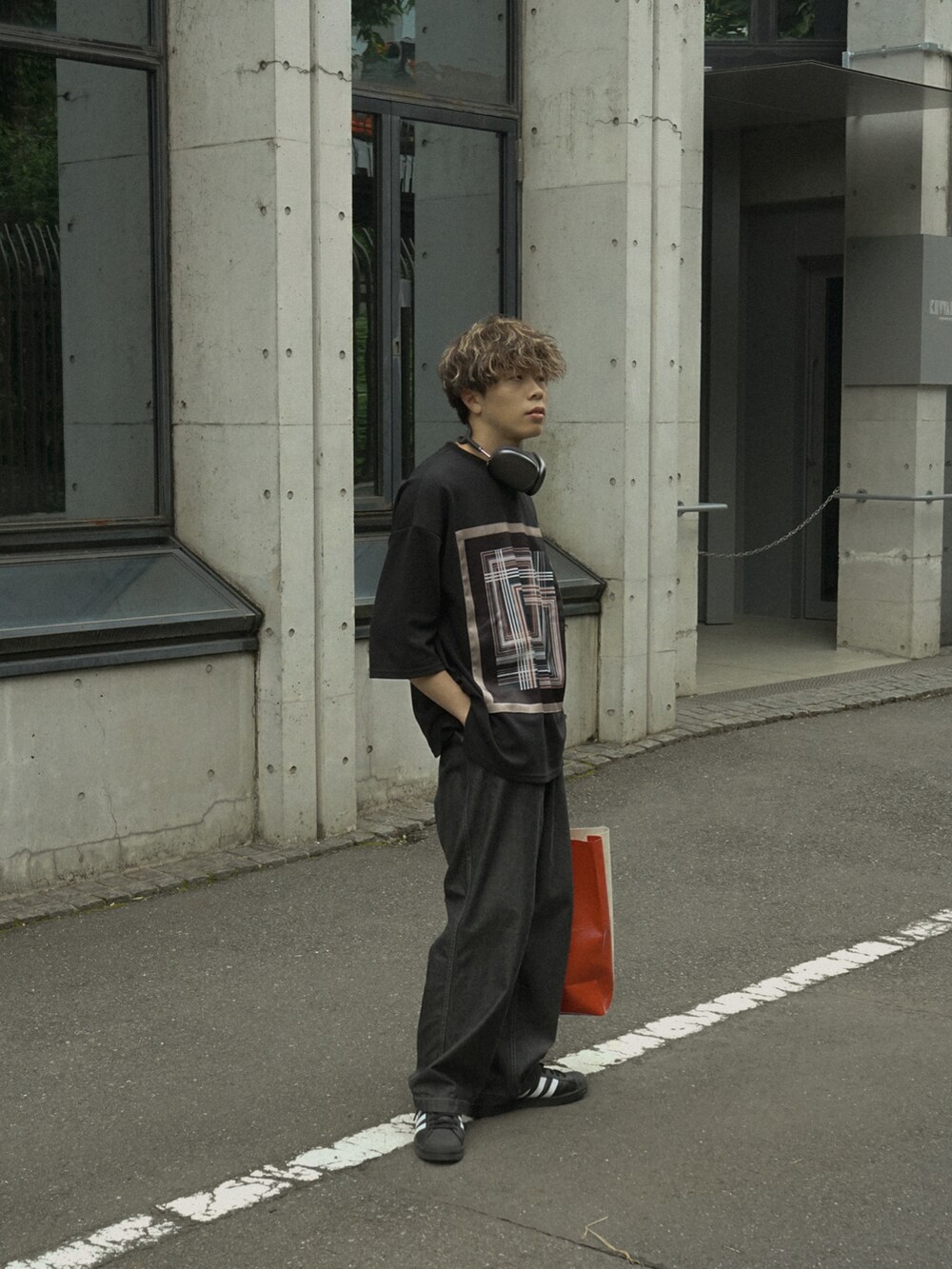 ブラック系のTシャツ/カットソー、グレー系のデニムパンツ、ホワイト系のトートバッグを着用したメンズの春コーディネートの3枚目の写真