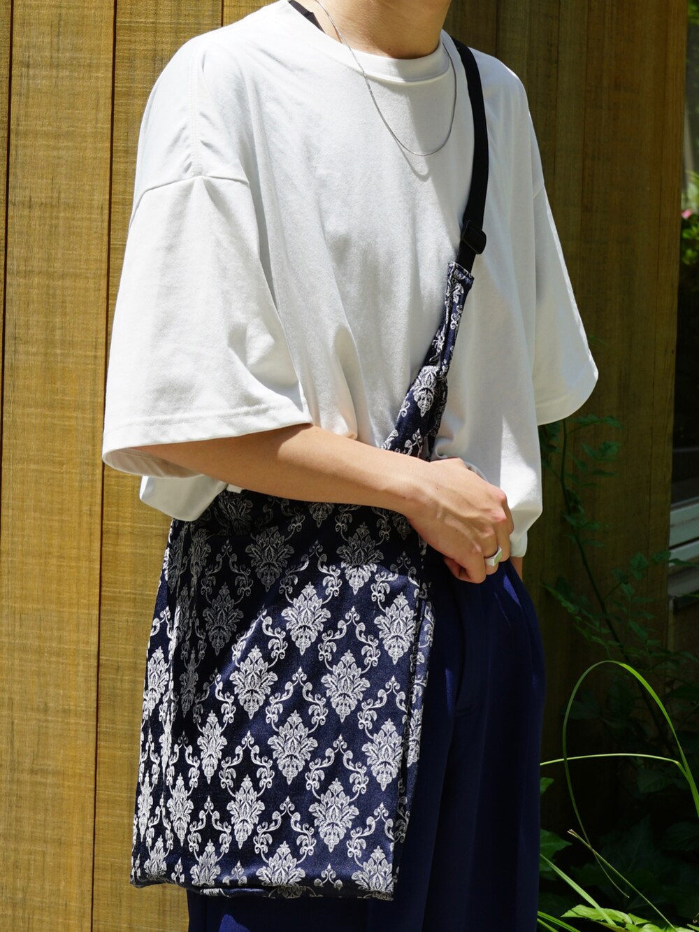 ホワイト系のTシャツ/カットソー、ブルー系のスラックス、ブルー系のショルダーバッグを着用したメンズの夏コーディネートの5枚目の写真