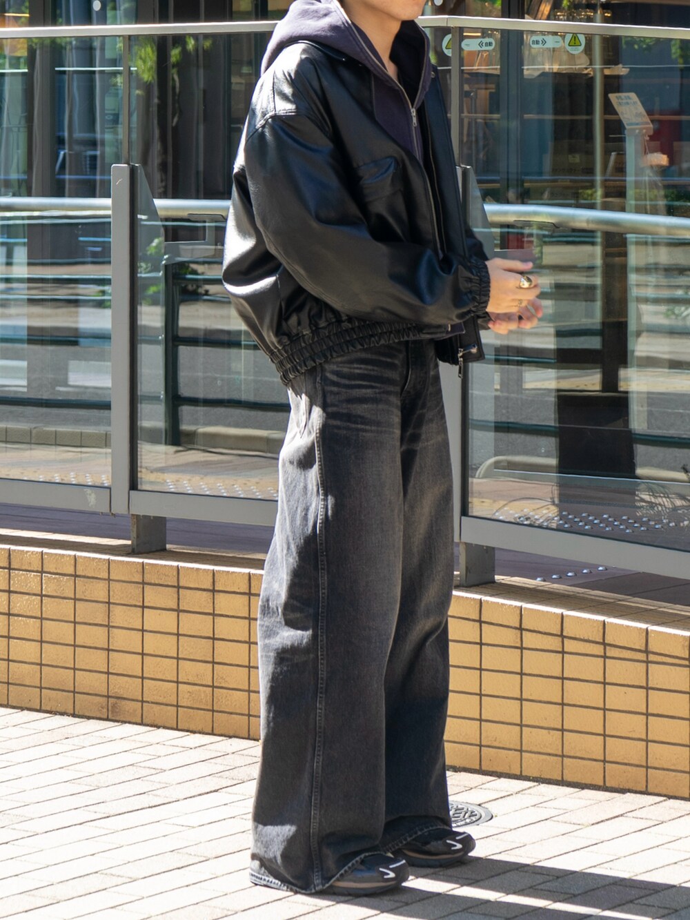 ブラック系のブルゾン、ブラック系のパーカー、ブラック系のデニムパンツを着用したメンズの秋コーディネートの5枚目の写真