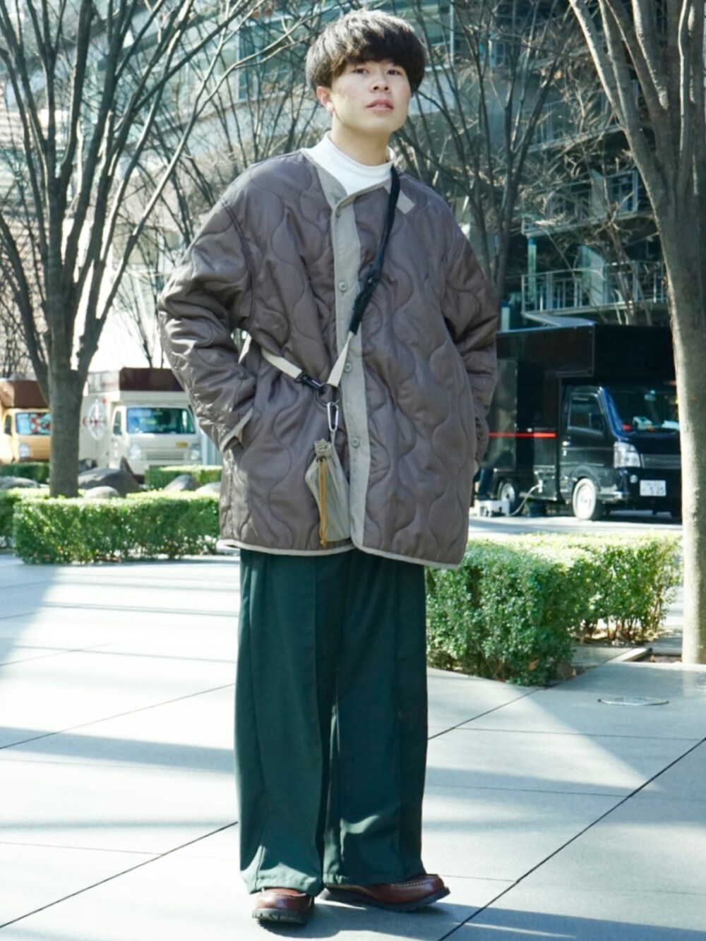 ベージュ系のその他アウター、ベージュ系のショルダーバッグ、グリーン系のその他パンツを着用したメンズの冬コーディネートの2枚目の写真