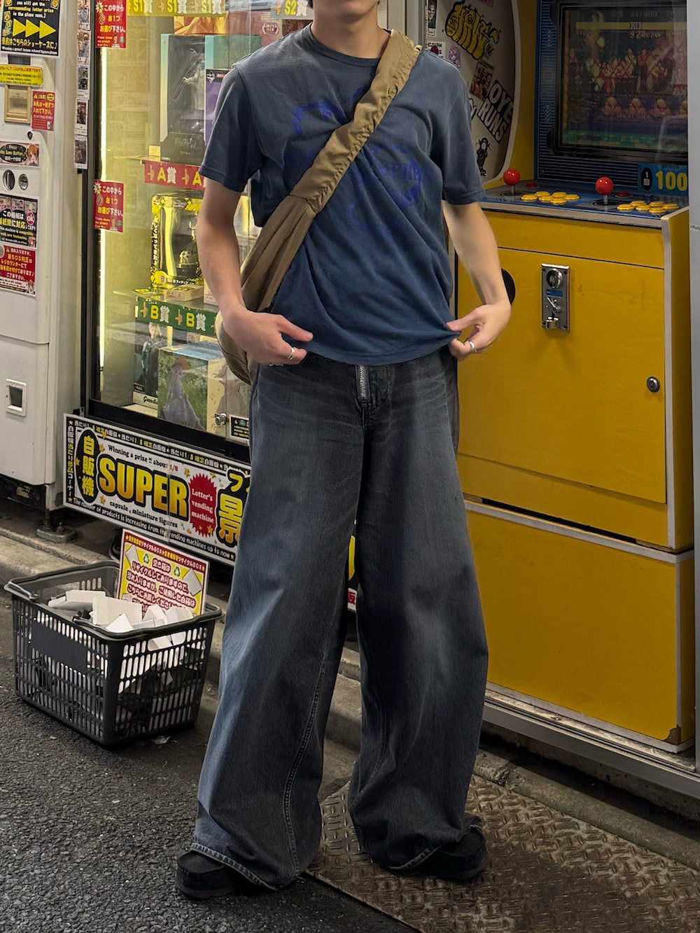 ブルー系のTシャツ/カットソー、ブルー系のデニムパンツ、ベージュ系のショルダーバッグを着用したメンズの夏コーディネートの5枚目の写真