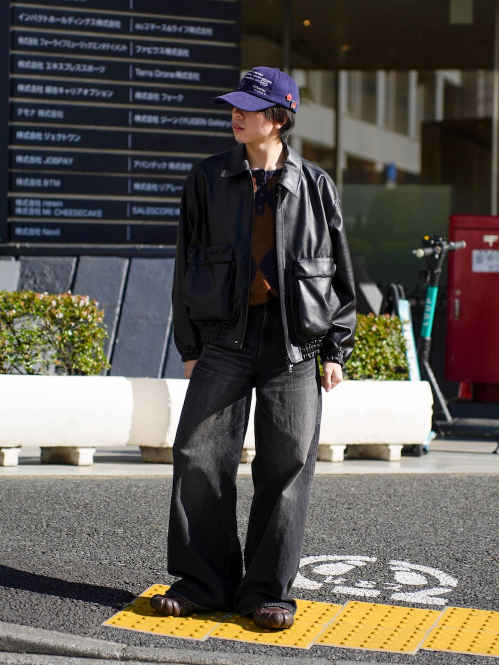 ブラック系のブルゾン、ブラック系のデニムパンツ、ブラウン系のスニーカーを着用したメンズの秋コーディネートの5枚目の写真