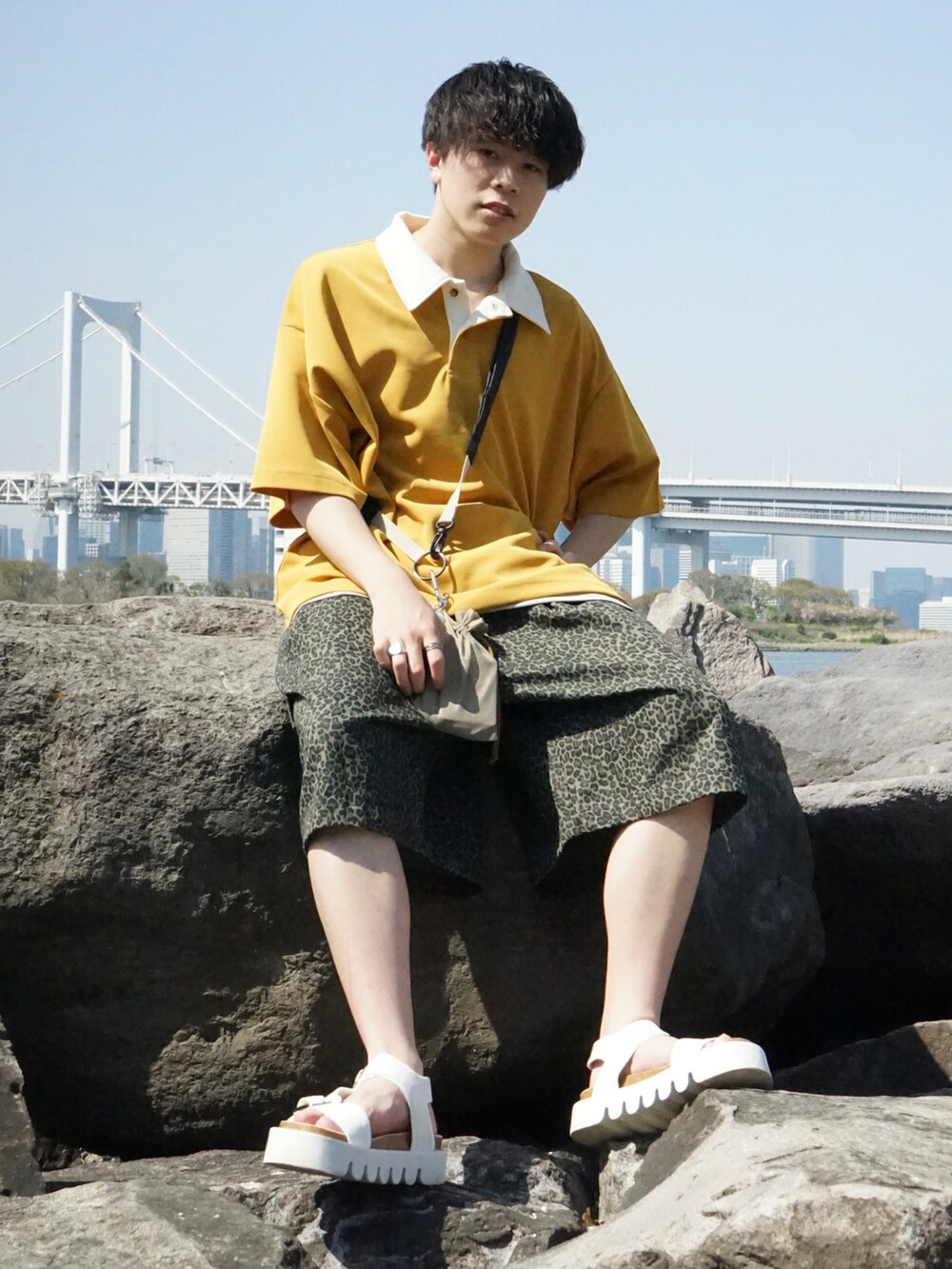 イエロー系のポロシャツ、グリーン系のその他パンツ、ホワイト系のサンダルを着用したメンズの春コーディネートの2枚目の写真