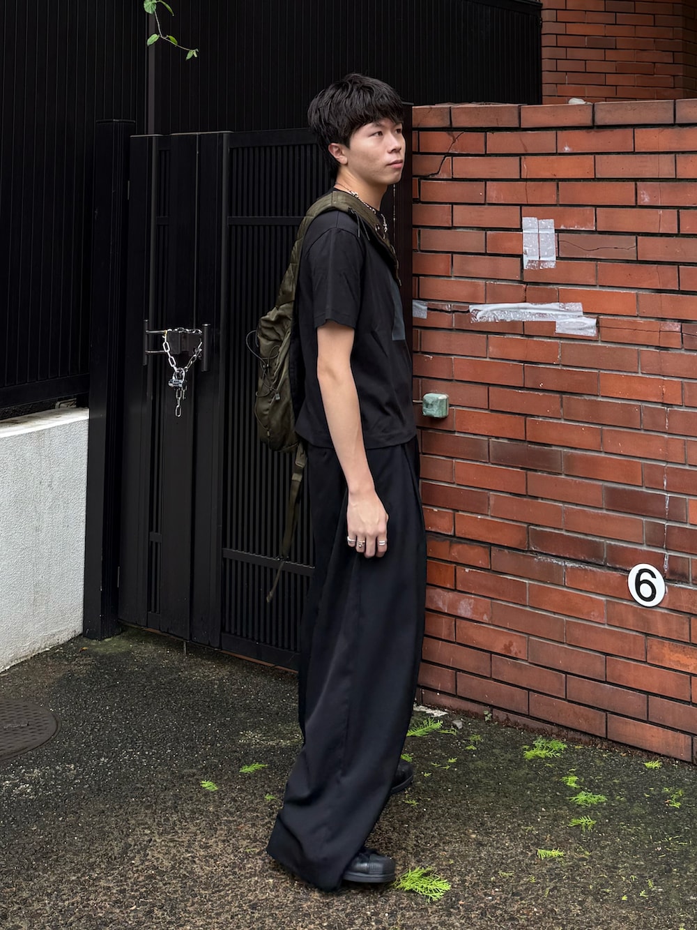 その他のTシャツ/カットソー、ブラック系のスラックス、グリーン系のバックパック/リュックを着用したメンズの夏コーディネートの2枚目の写真