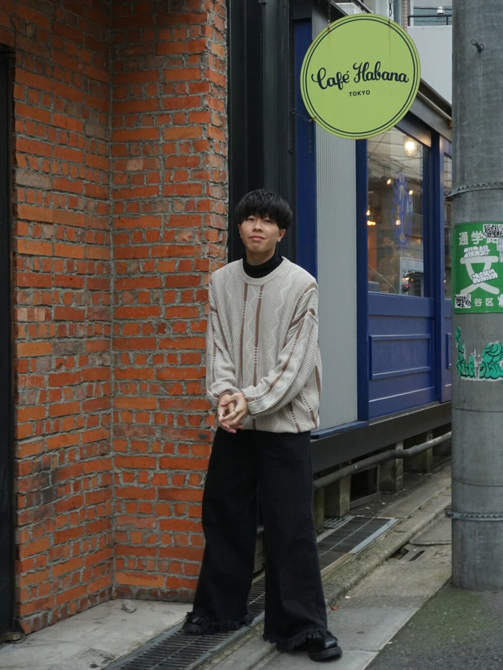 ベージュ系のニット/セーター、ブラック系のTシャツ/カットソー、ブラック系のデニムパンツを着用したメンズの冬コーディネートの2枚目の写真