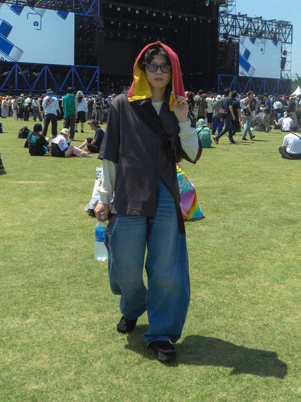 グレー系のトップス、ブラック系のショルダーバッグ、ブルー系のデニムパンツを着用したメンズの春コーディネートの2枚目の写真