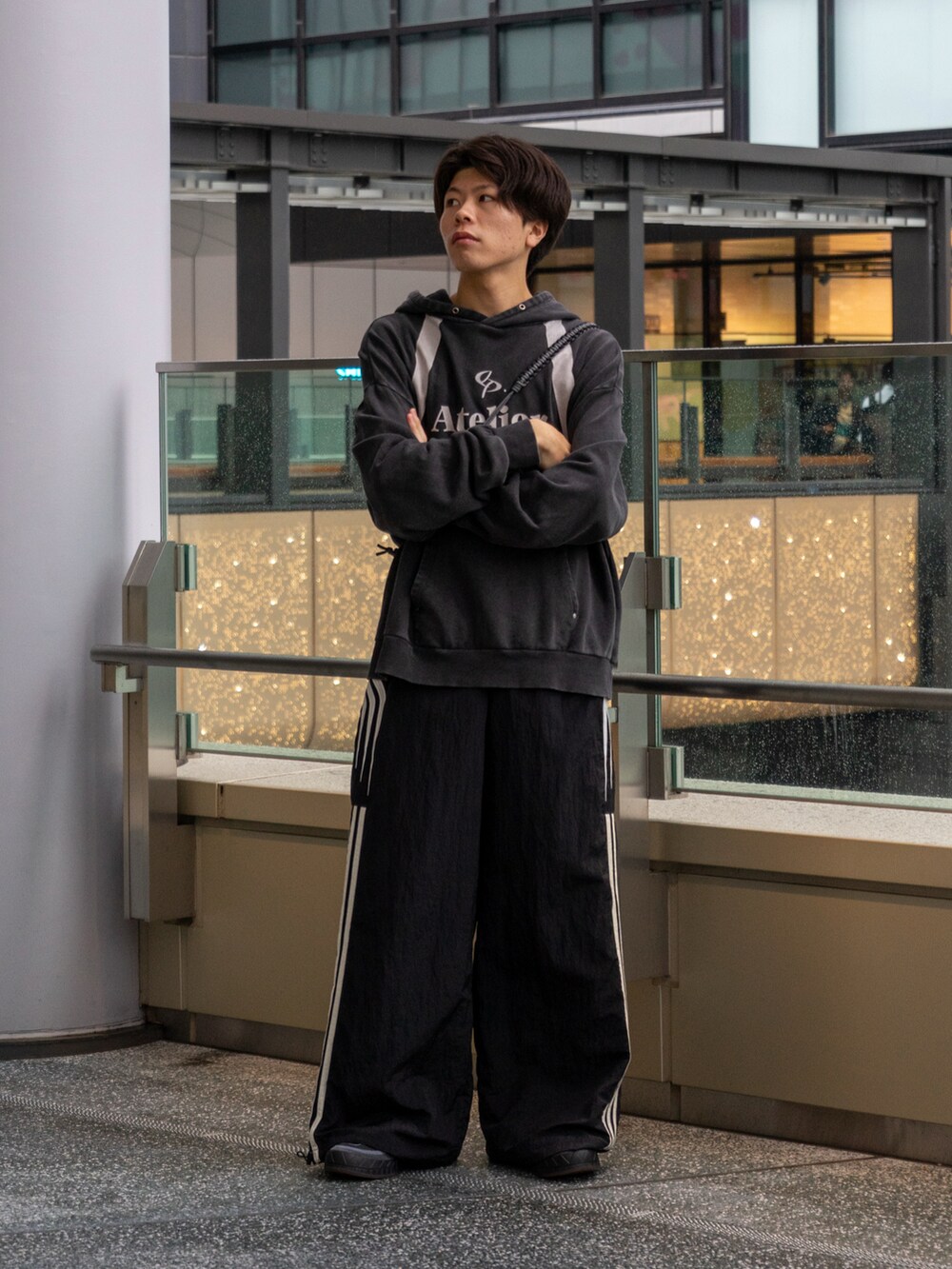 ブラック系のパーカー、ブラック系のスウェットパンツ、ブラウン系のショルダーバッグを着用したメンズの秋コーディネートの2枚目の写真