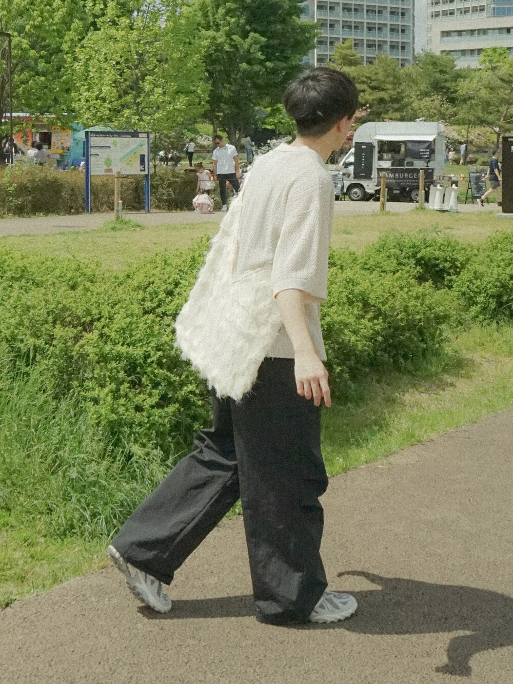 ホワイト系のカーディガン/ボレロ、ブラック系のその他パンツ、ホワイト系のショルダーバッグを着用したメンズの春コーディネートの2枚目の写真