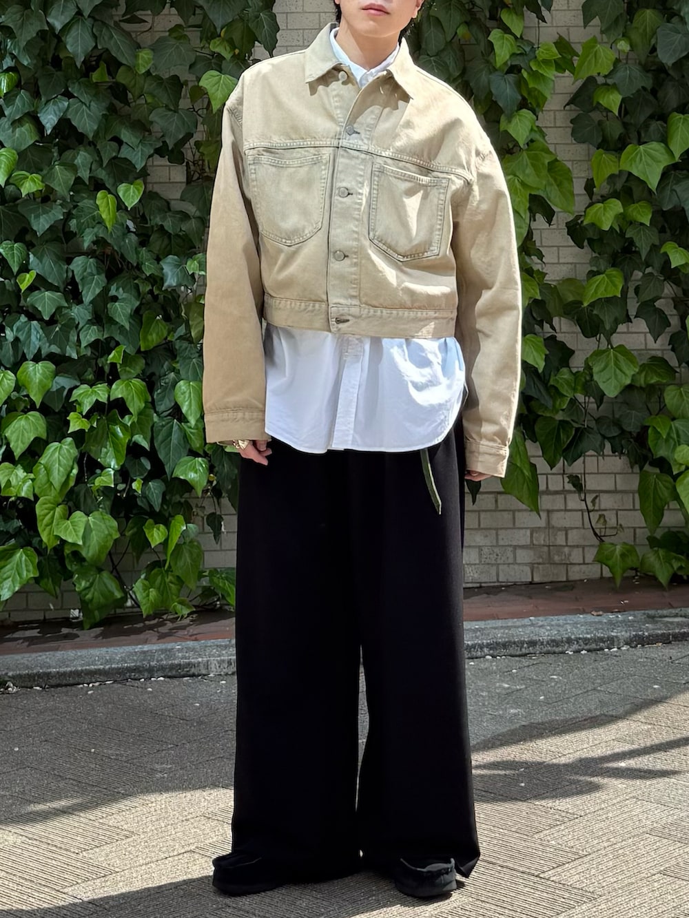 ベージュ系のデニムジャケット、ホワイト系のシャツ/ブラウス、ブラック系のスラックスを着用したメンズの春コーディネートの3枚目の写真