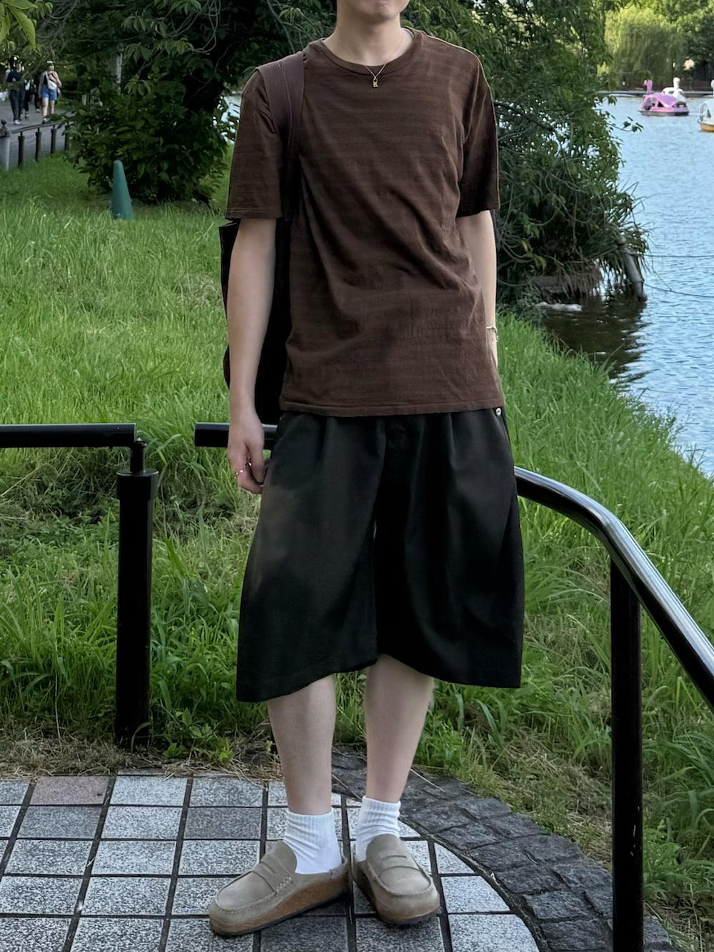 ブラウン系のTシャツ/カットソー、グリーン系のスラックス、ブラウン系のトートバッグを着用したメンズの夏コーディネートの4枚目の写真