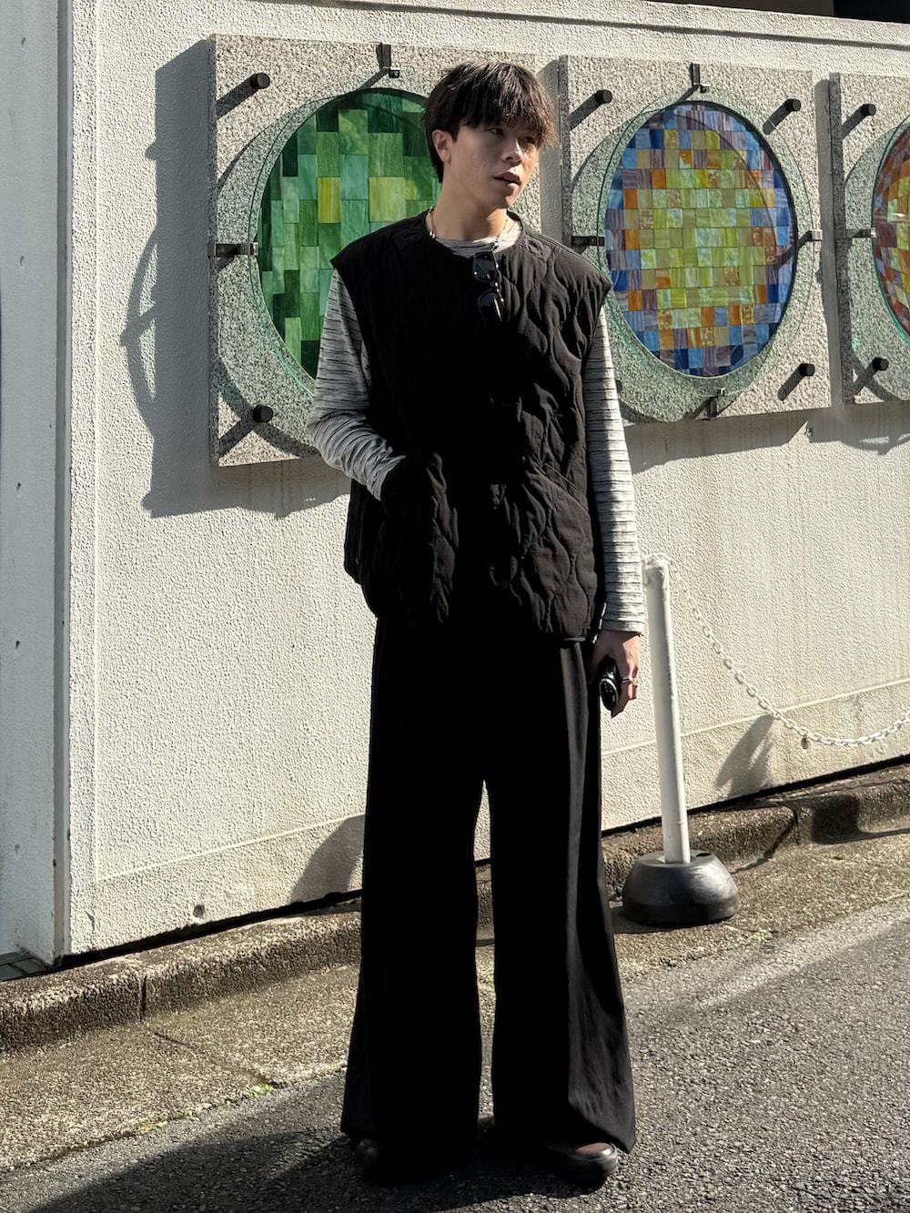 ブラック系のその他アウター、グレー系のTシャツ/カットソー、グレー系のスラックスを着用したメンズの春コーディネートの2枚目の写真