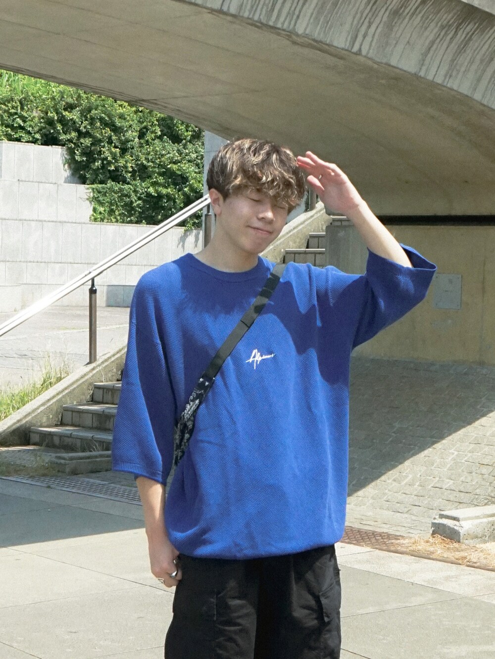 ブルー系のショルダーバッグ、ブラック系のスニーカー、ブルー系のその他を着用したメンズの夏コーディネートの4枚目の写真