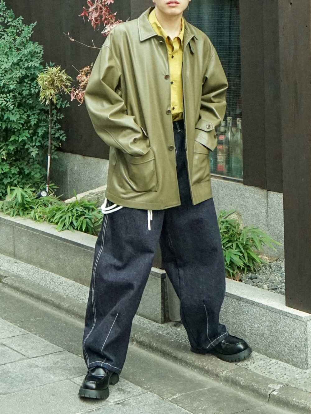 グリーン系のカバーオール、イエロー系のシャツ/ブラウス、ブルー系のデニムパンツを着用したメンズの冬コーディネートの5枚目の写真