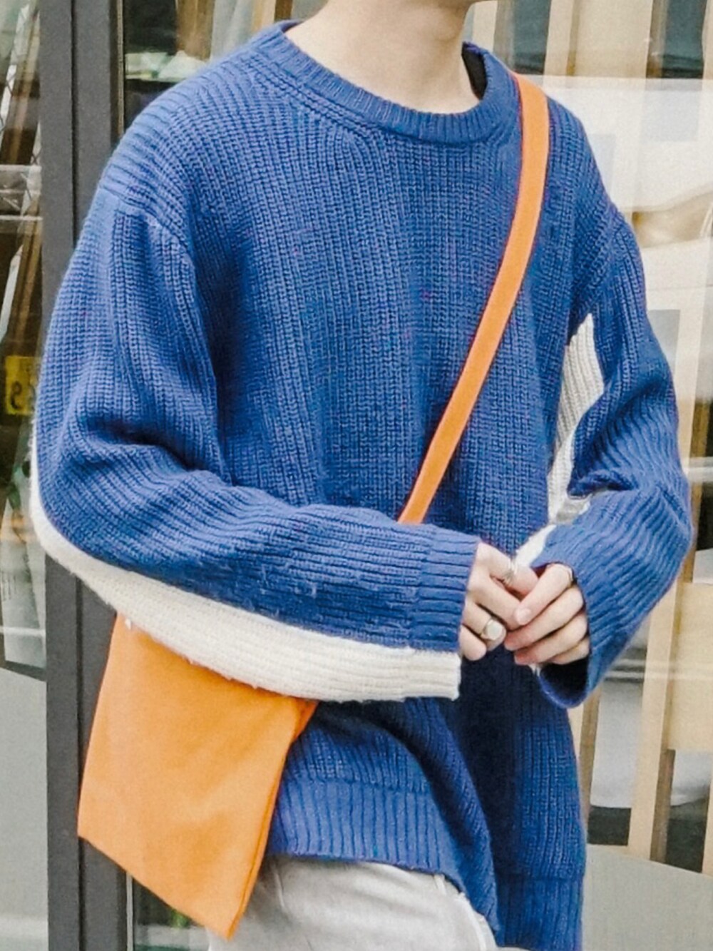 ブルー系のニット/セーター、グレー系のスウェットパンツ、オレンジ系のショルダーバッグを着用したメンズの春コーディネートの4枚目の写真