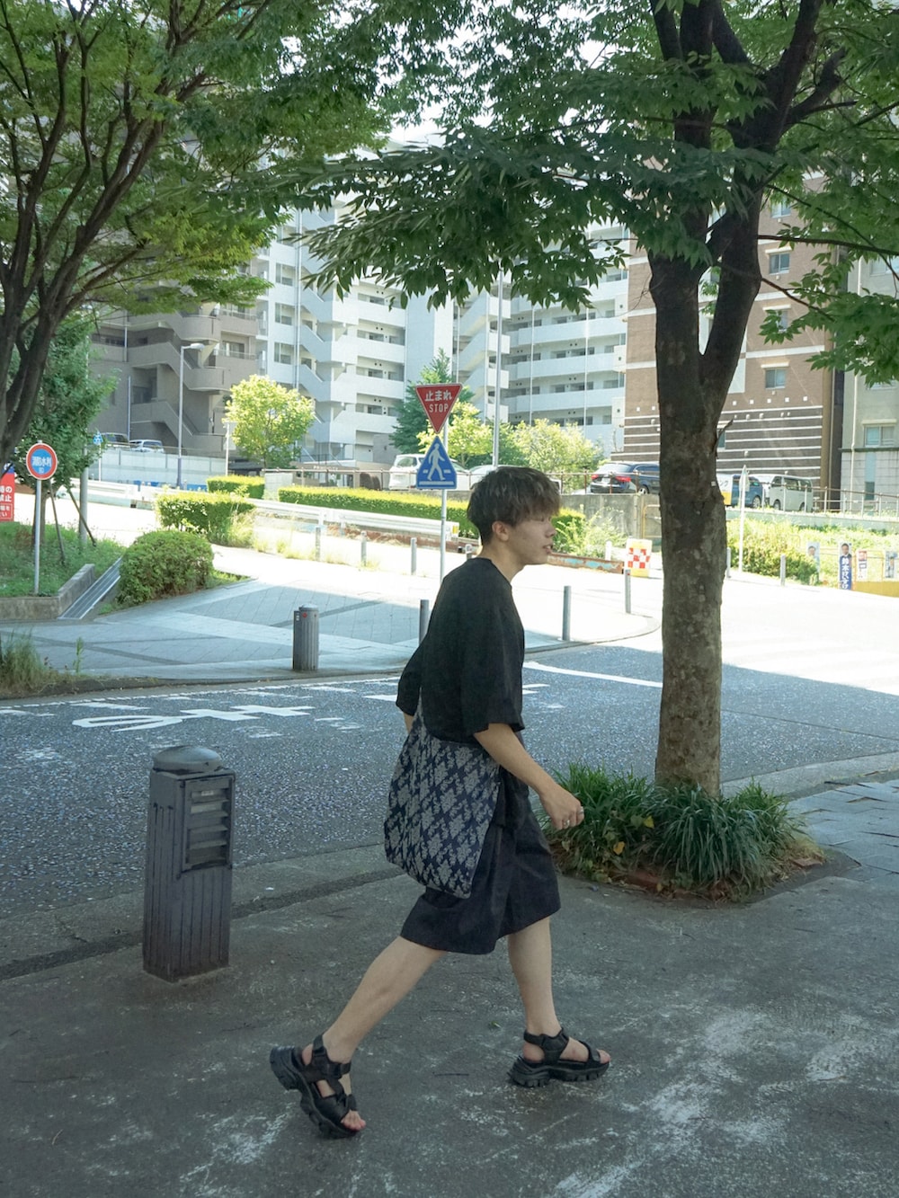 ブラック系のTシャツ/カットソー、ブラック系のその他パンツ、ブルー系のショルダーバッグを着用したメンズの夏コーディネートの3枚目の写真