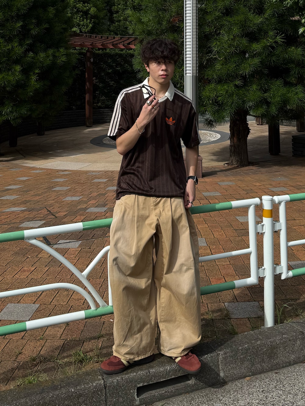 ブラウン系のTシャツ/カットソー、ベージュ系のチノパンツ、ブラウン系のスニーカーを着用したメンズの夏コーディネートの2枚目の写真