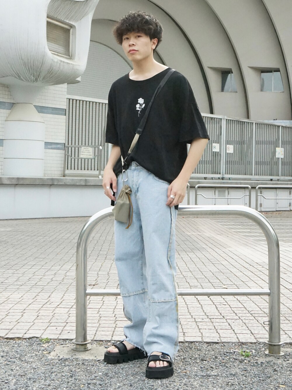 ブラック系のTシャツ/カットソー、ベージュ系のショルダーバッグ、ブルー系のデニムパンツを着用したメンズの春コーディネートの2枚目の写真